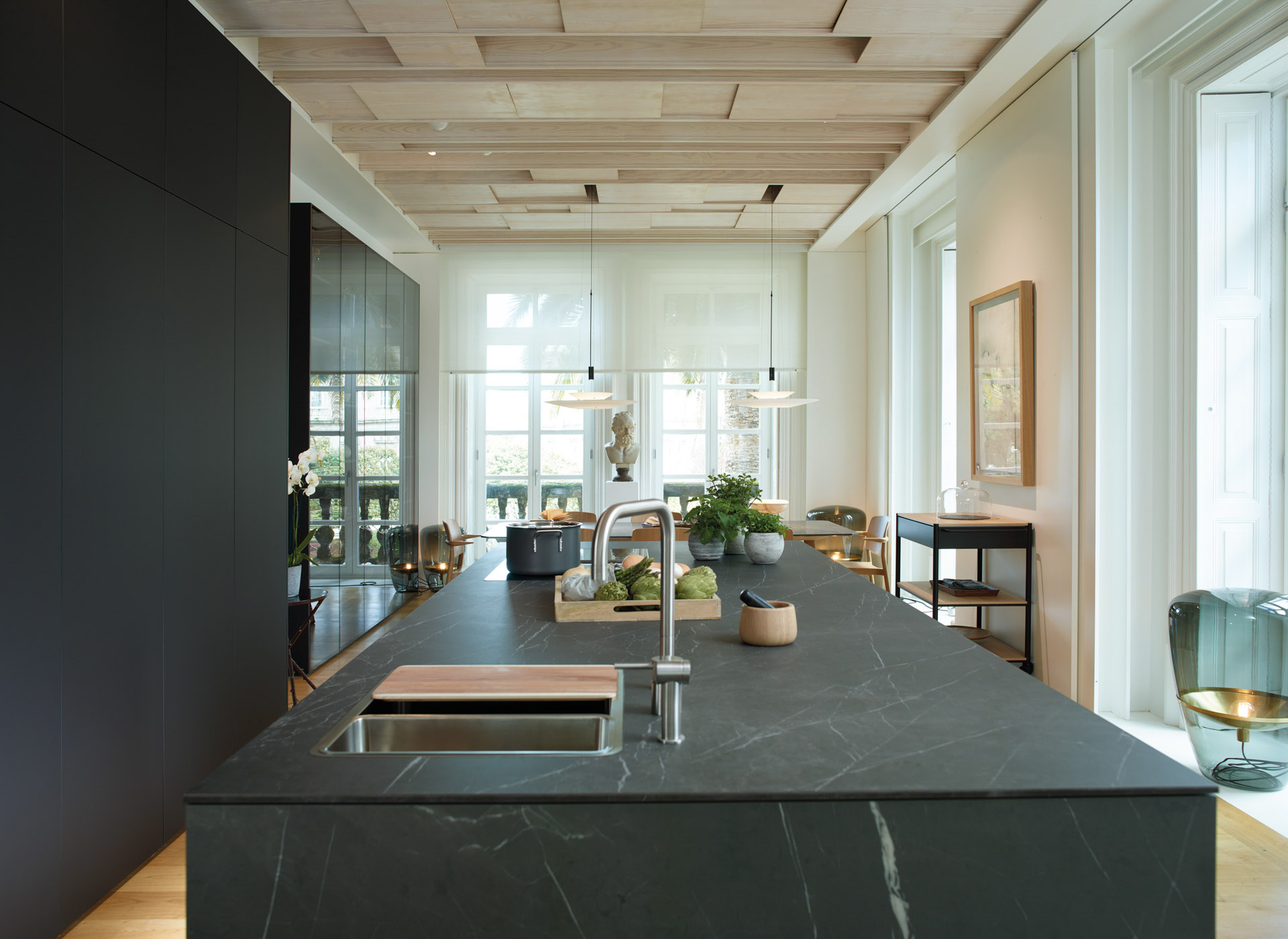 Cocina abierta con isla luminosa y muebles columna