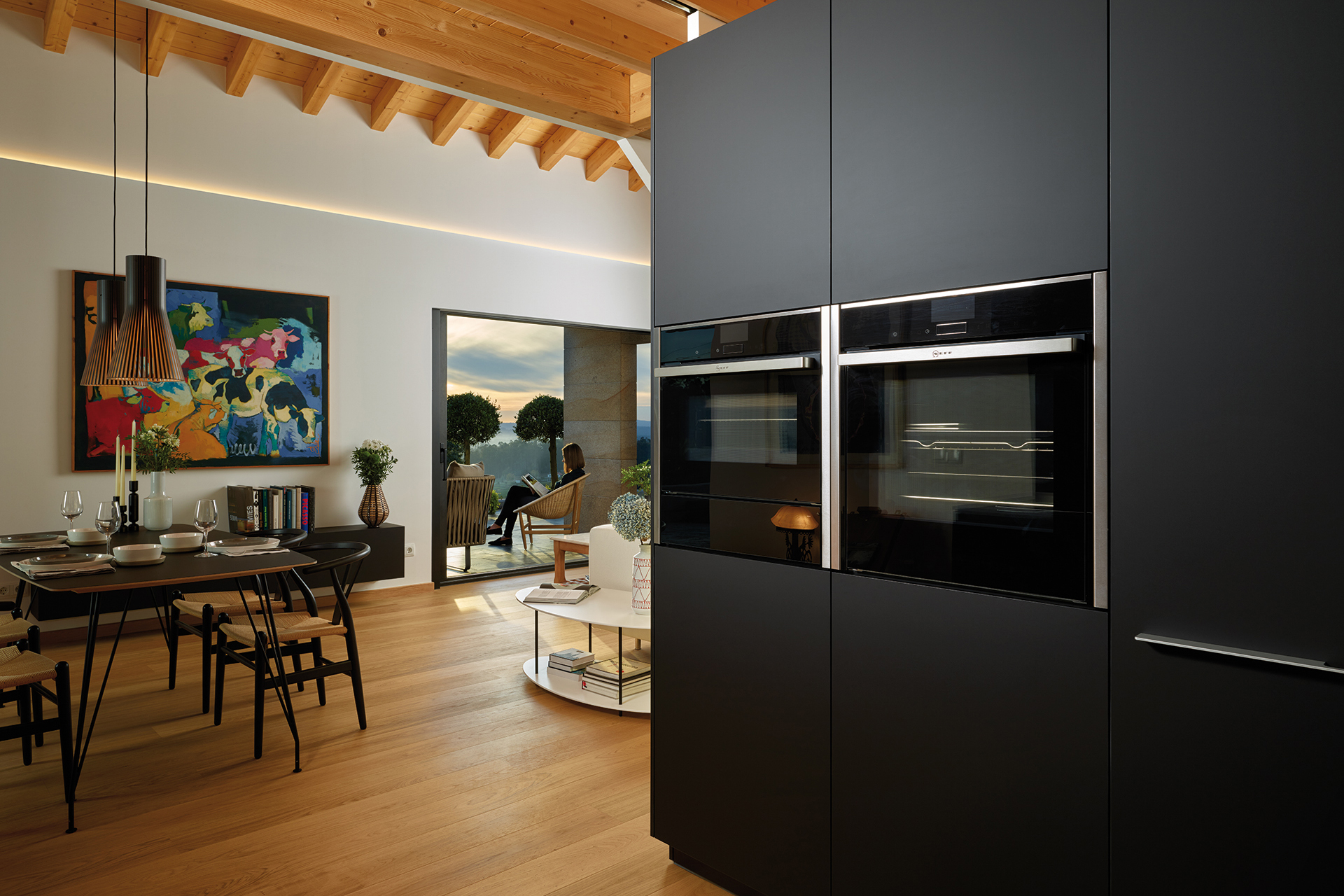 Black parallel kitchen that opens into the dining room, fitted with cabinets designed by Santos