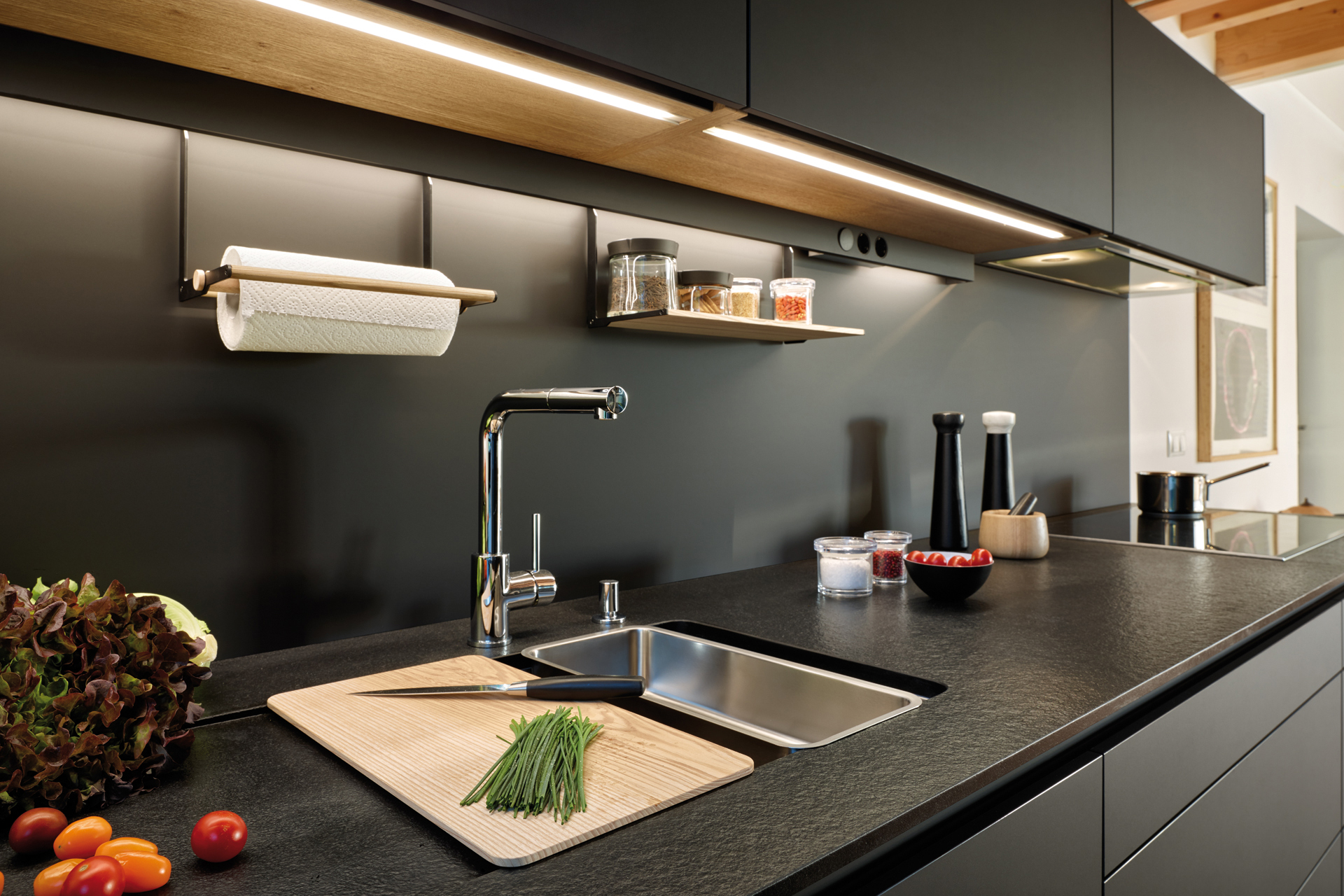 Cuisine noire ouverte sur le salon, équipée de meubles conçus par Santos