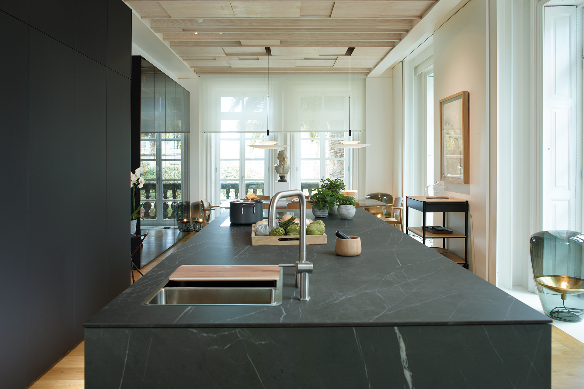 Cocina con isla abierta al salón y al comedor, equipada con muebles diseñados por Santos