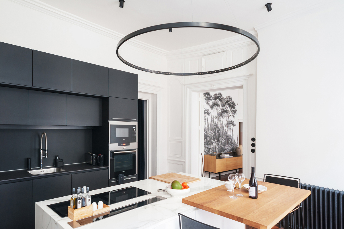 Cuisine Santos noire avec îlot dans un appartement à l'esprit bohème