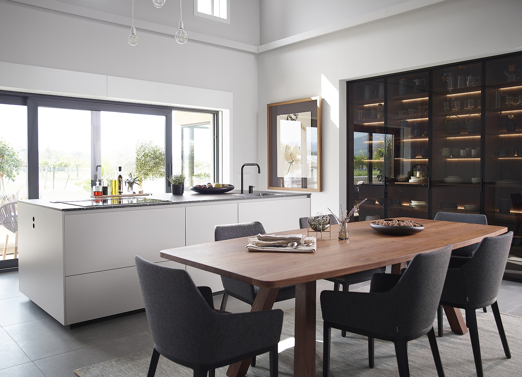Cocina con isla, mesa y vitrina negra