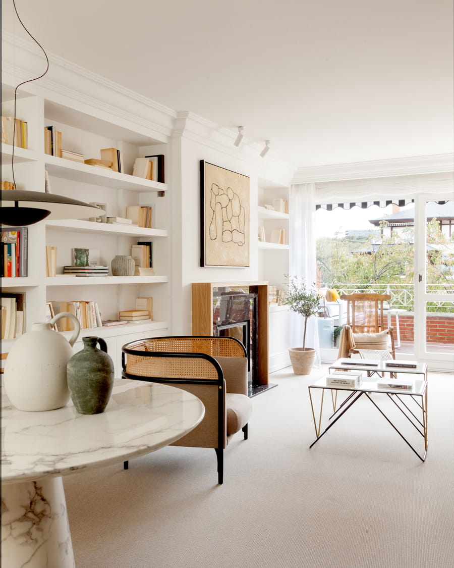 White living room with table and shelves