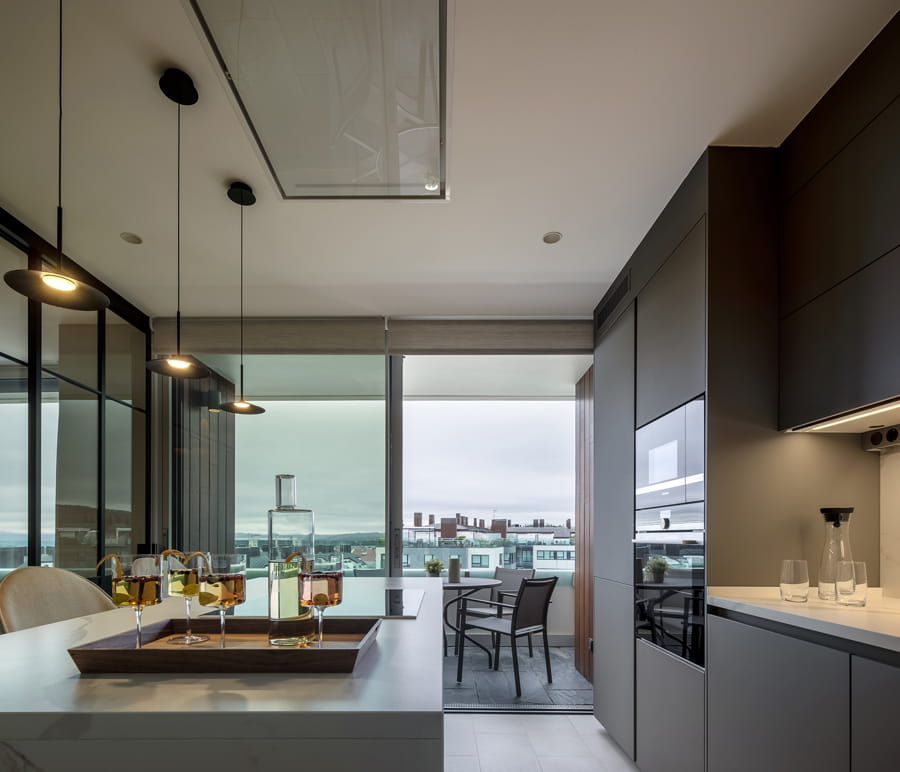 Grey kitchen with island that opens out to the outdoor terrace