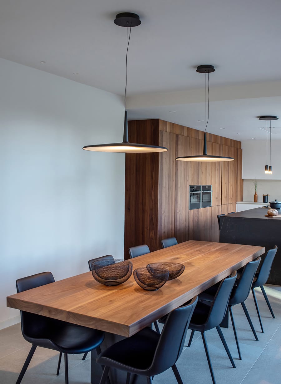 Sala de jantar com mesa de madeira e cadeiras pretas
