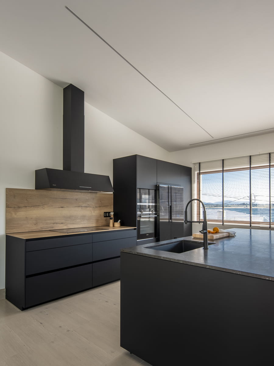 Cozinha aberta em preto e madeira