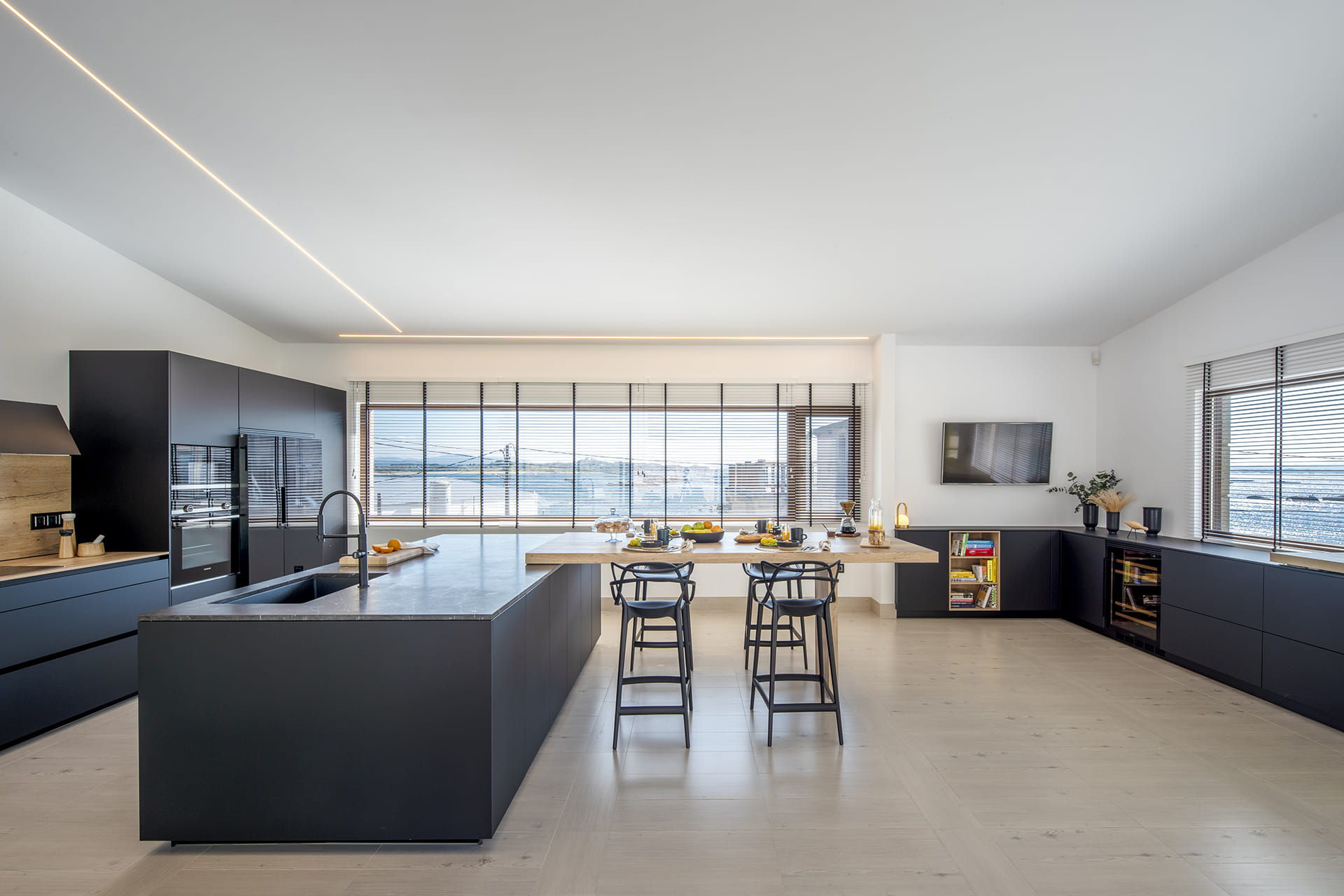 Cozinha com ilha com móveis pretos