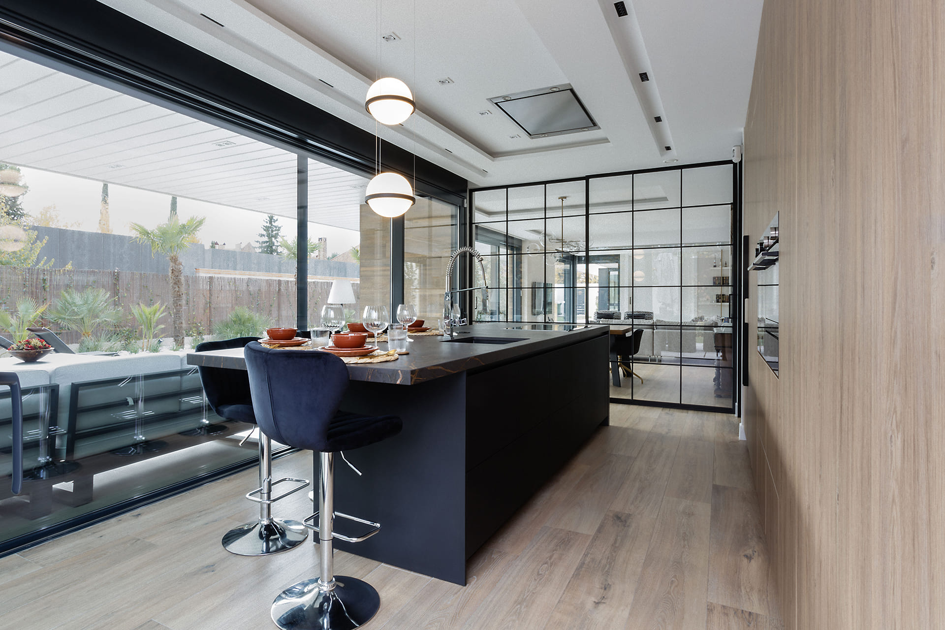 Une cuisine ouverte sur le salon, la salle à manger et le jardin