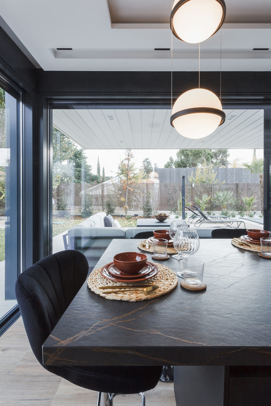 Cuisine avec îlot noir donnant sur le jardin
