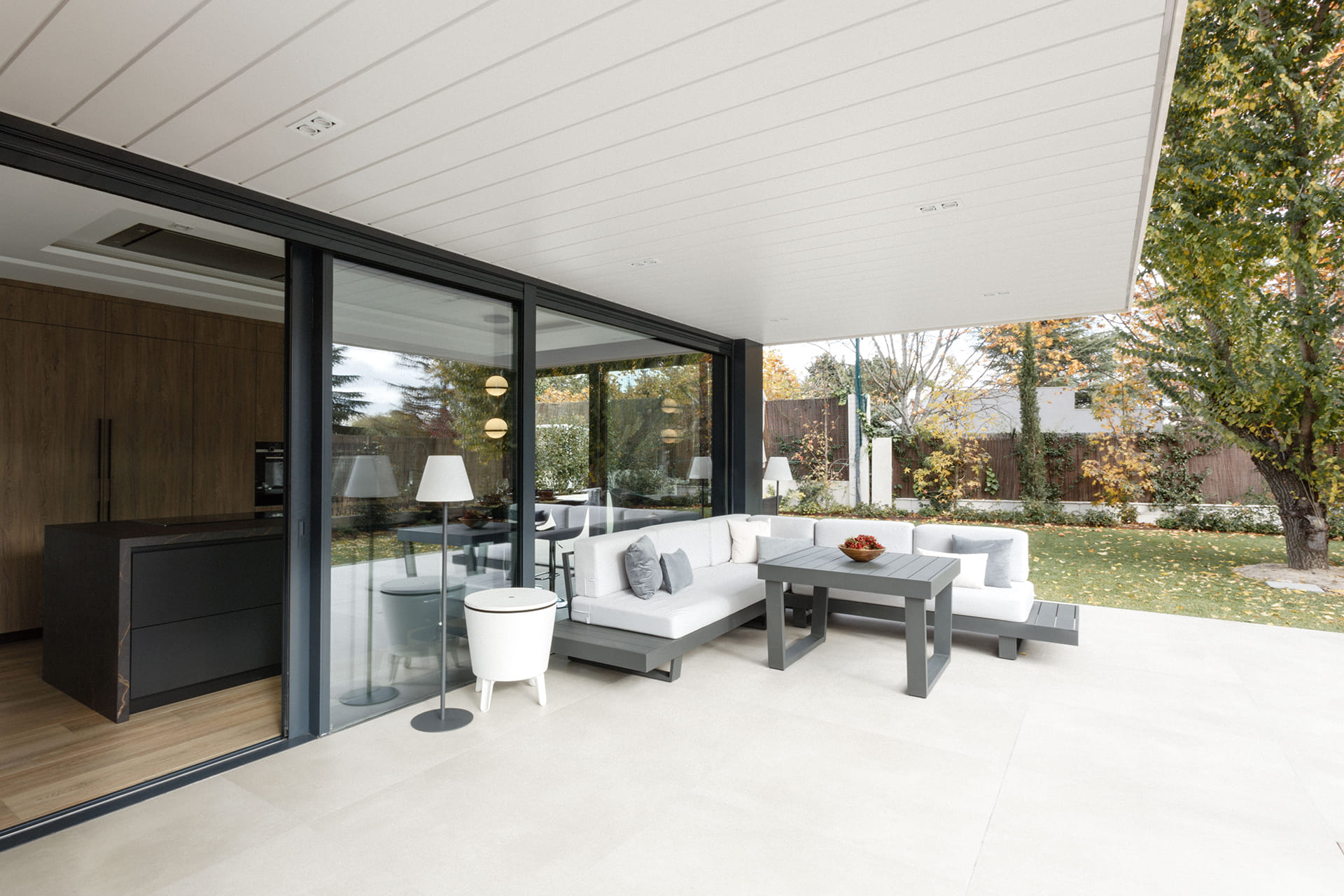 Salle de séjour ouverte sur le jardin avec table et canapé