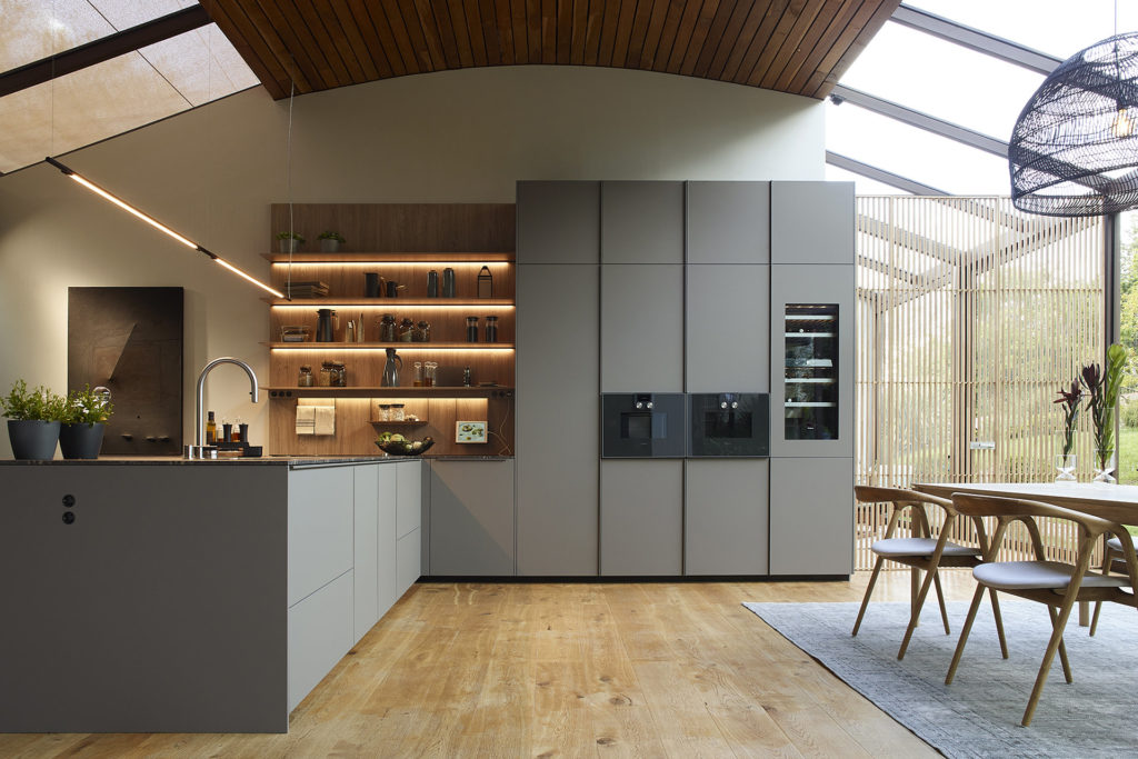 Grey kitchen with peninsula and shelving unit with lighting