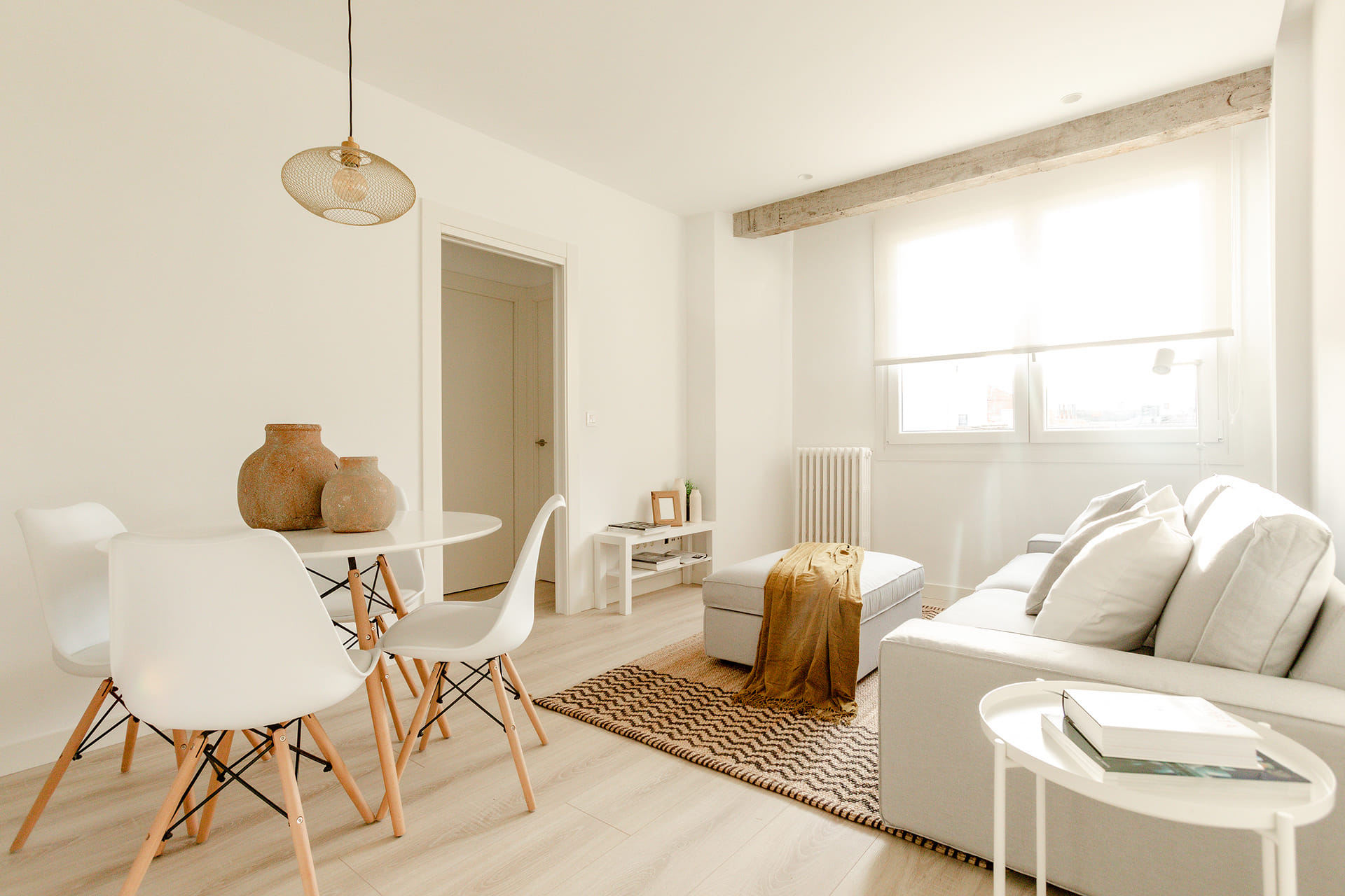 Sala de estar branca em apartamento remodelado