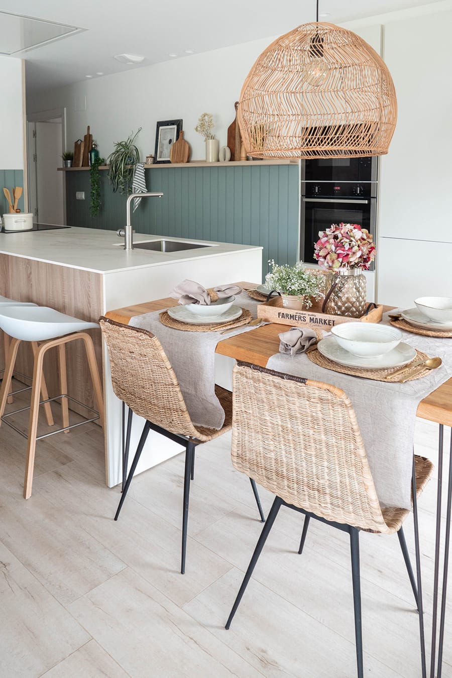 Witte keuken met schiereiland en tafel.
