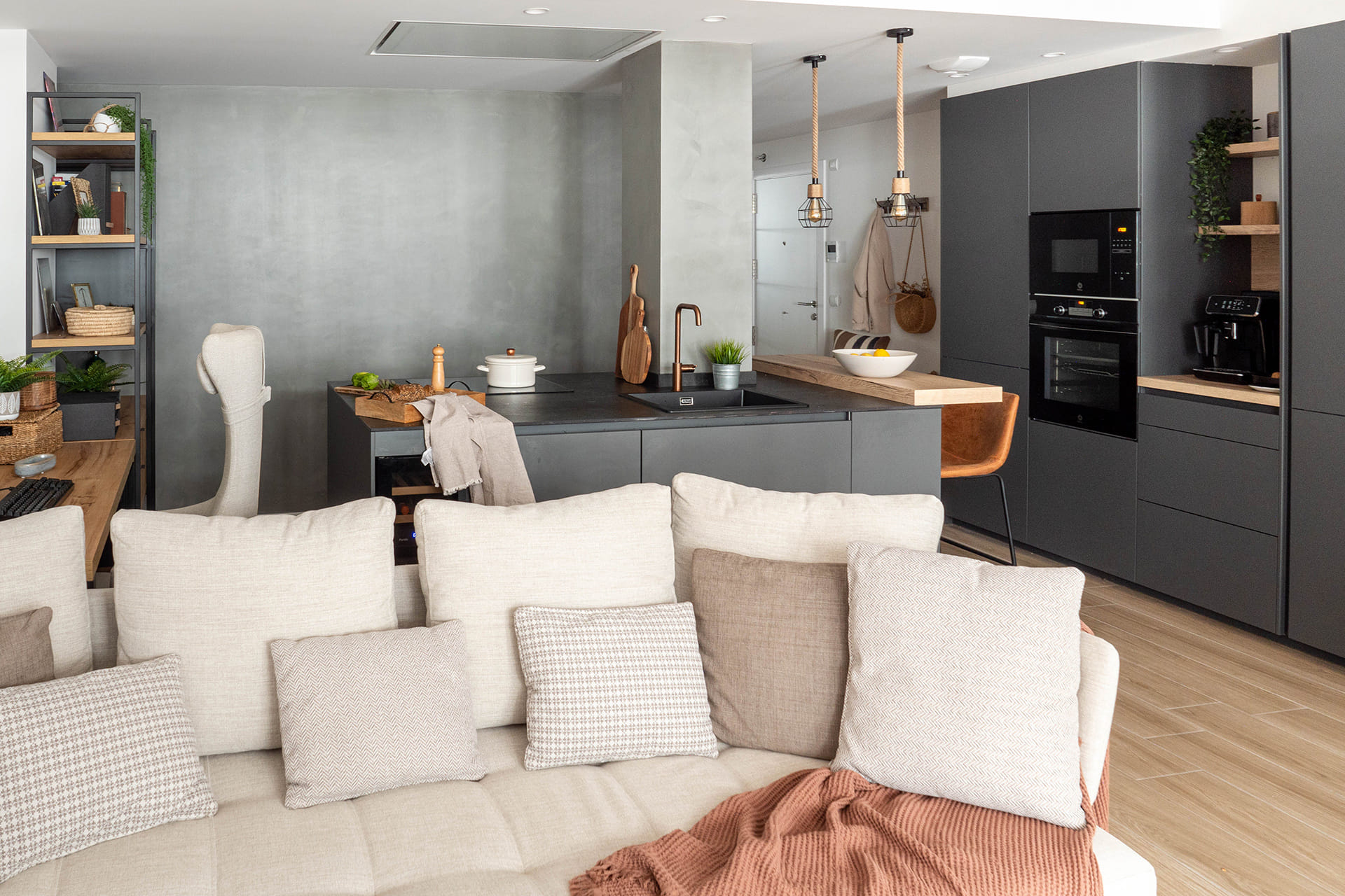 Antracietgrijze keuken met ontbijtbar, open naar de eetkamer.