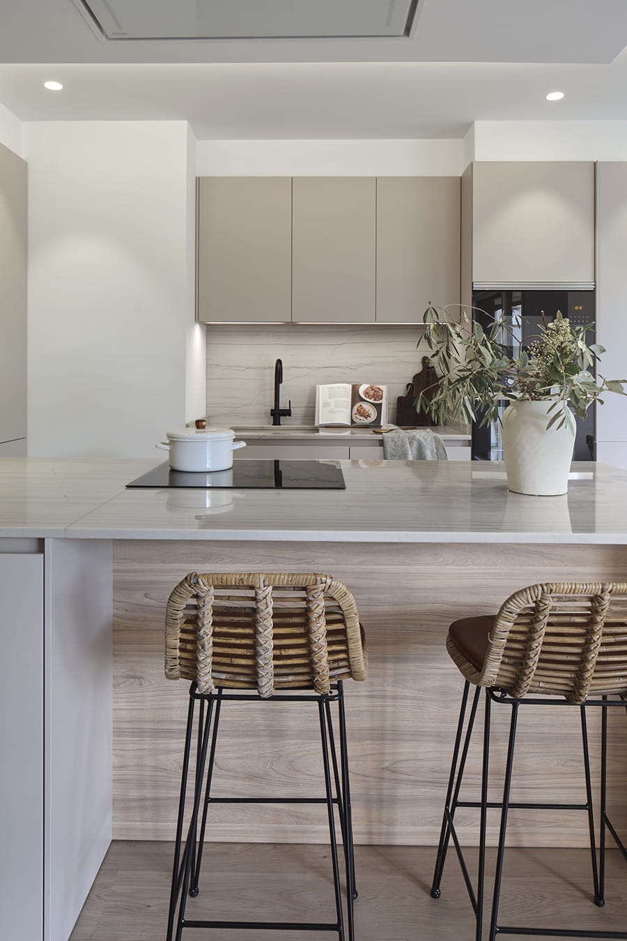 Santos keuken in Cashmere met wit schiereiland en houten details, harmonieus en functioneel.