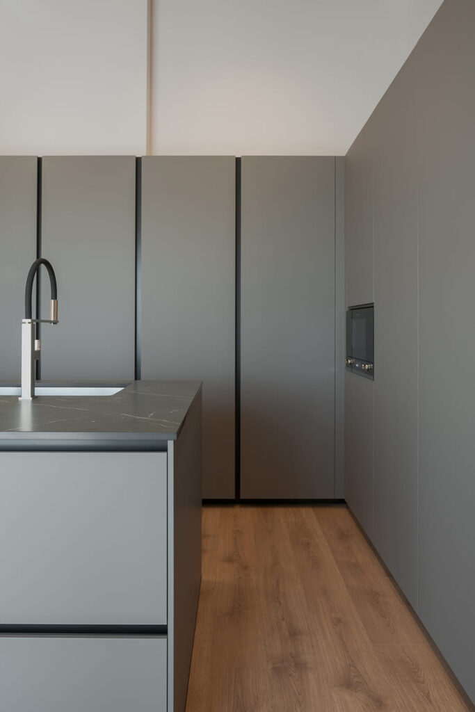 Tall units in grey kitchen, plenty of storage with centre island.