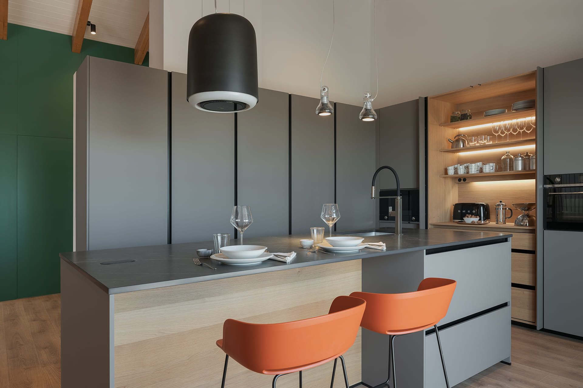 Grey kitchen with centre island and stools with pocket door cabinet.