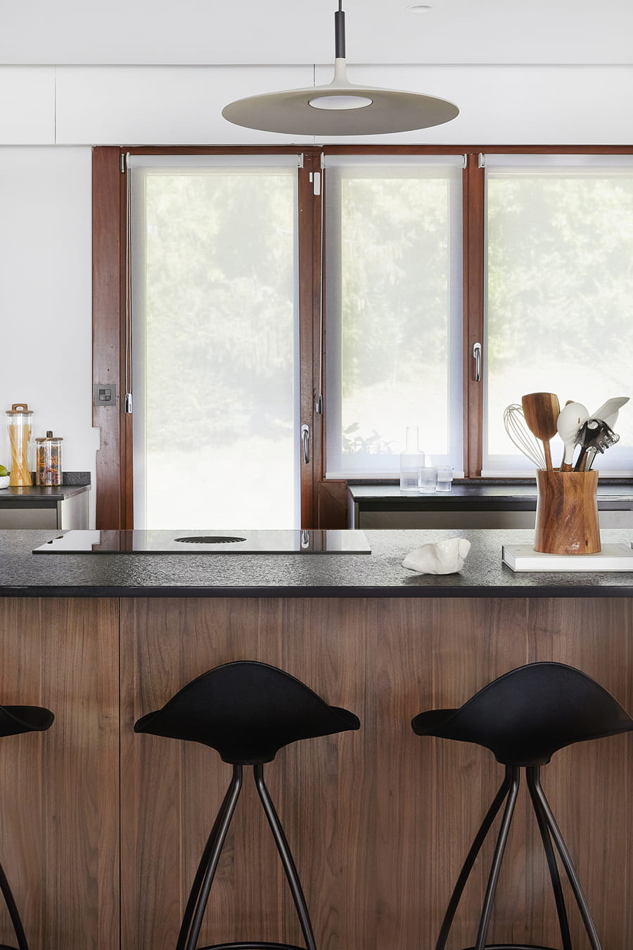 Kitchen with centre island in grey and walnut wood, open-plan design.