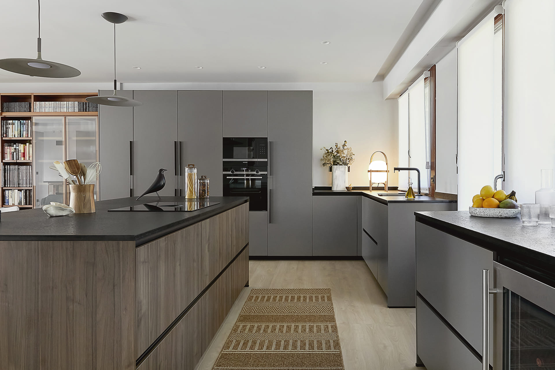 Grey and wood Santos kitchen open to the lounge with island clad in walnut.