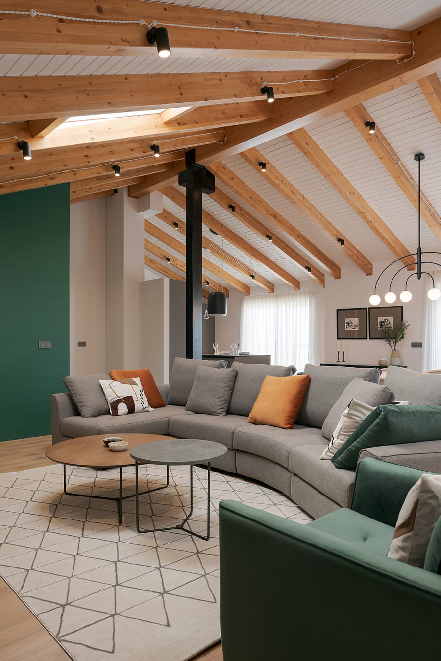 Large lounge with curved sofa in space open to Santos kitchen.