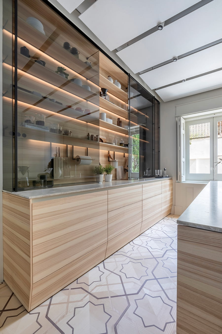 Santos kitchen in Olive Ash wood with large illuminated display cabinet at Casa Decor 2024.