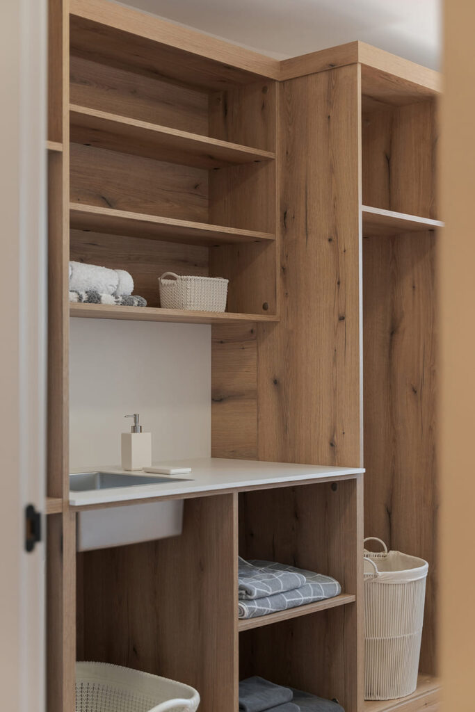 Laundry area with wooden cabinets.