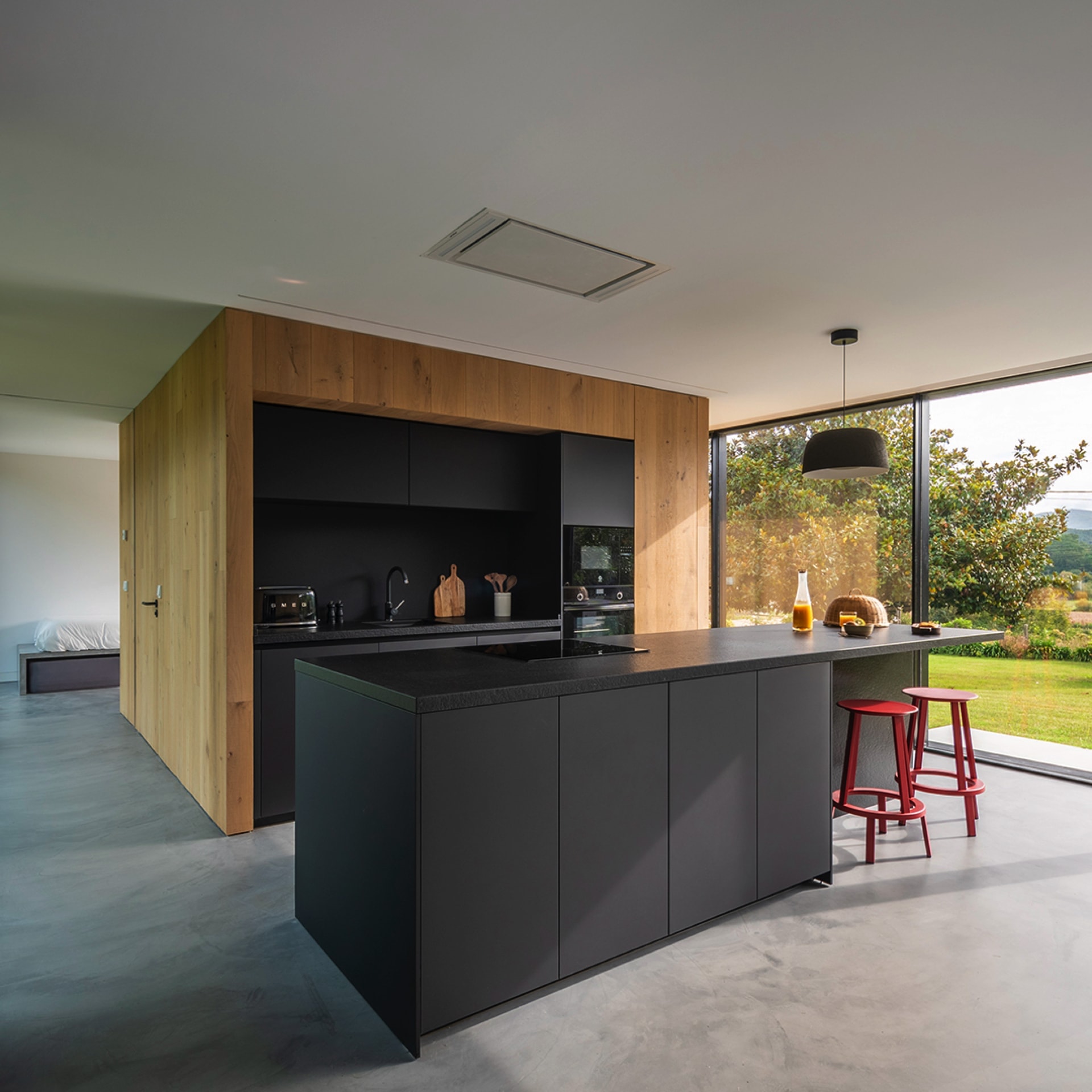 Cocina negra y madera amplia y luminosa
