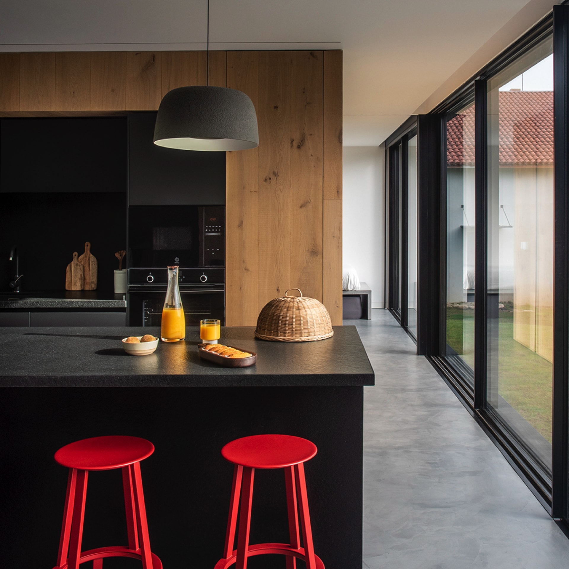 Cocina negra y madera con isla y lámpara