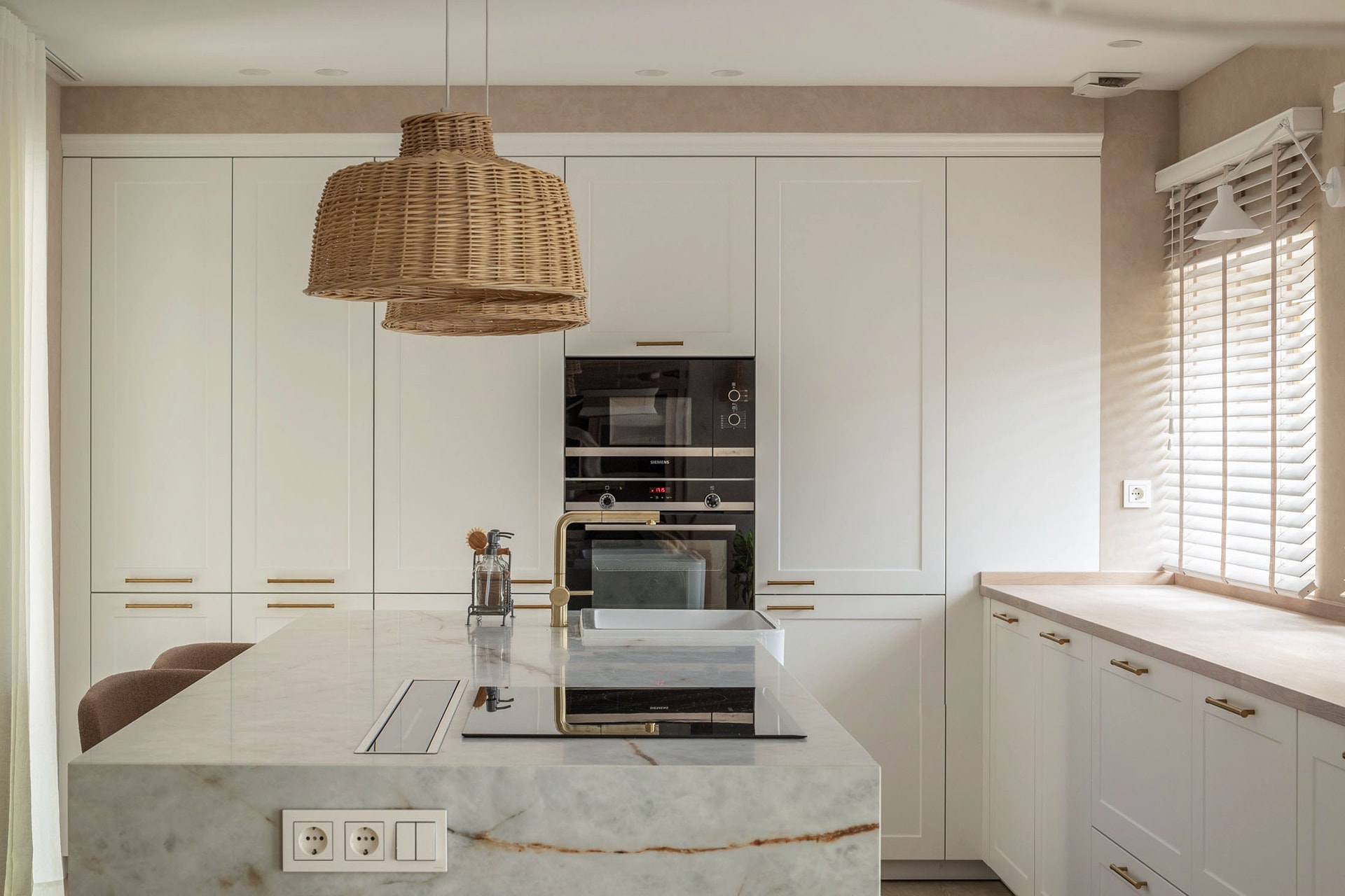 White kitchen with tall units and island.