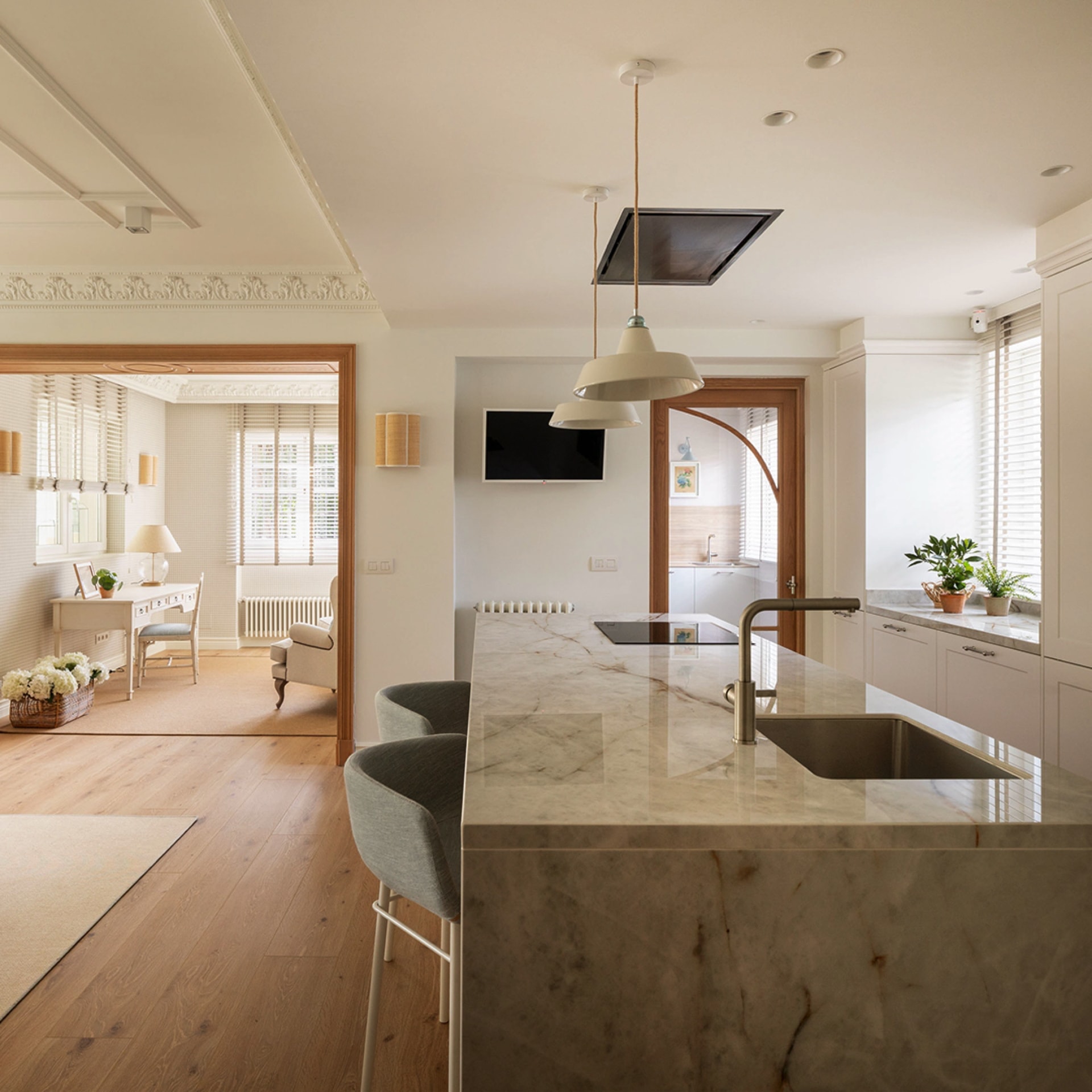 Kitchen with white and wood island open to the lounge