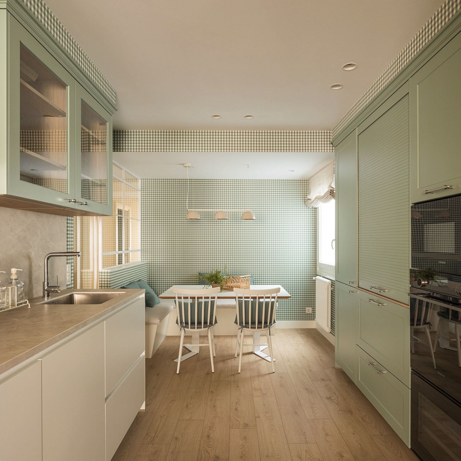 Kitchen with green cabinets and centre table.