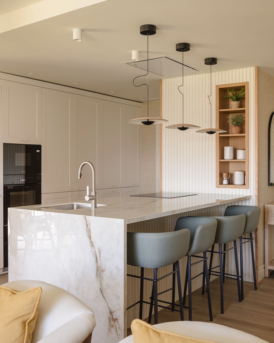 Kitchen with peninsula, stools and lamps.