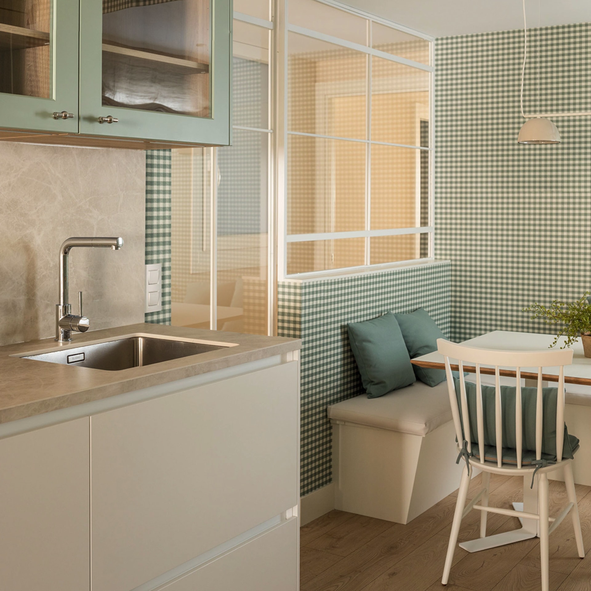 Table with benches in green kitchen with eat-in area.