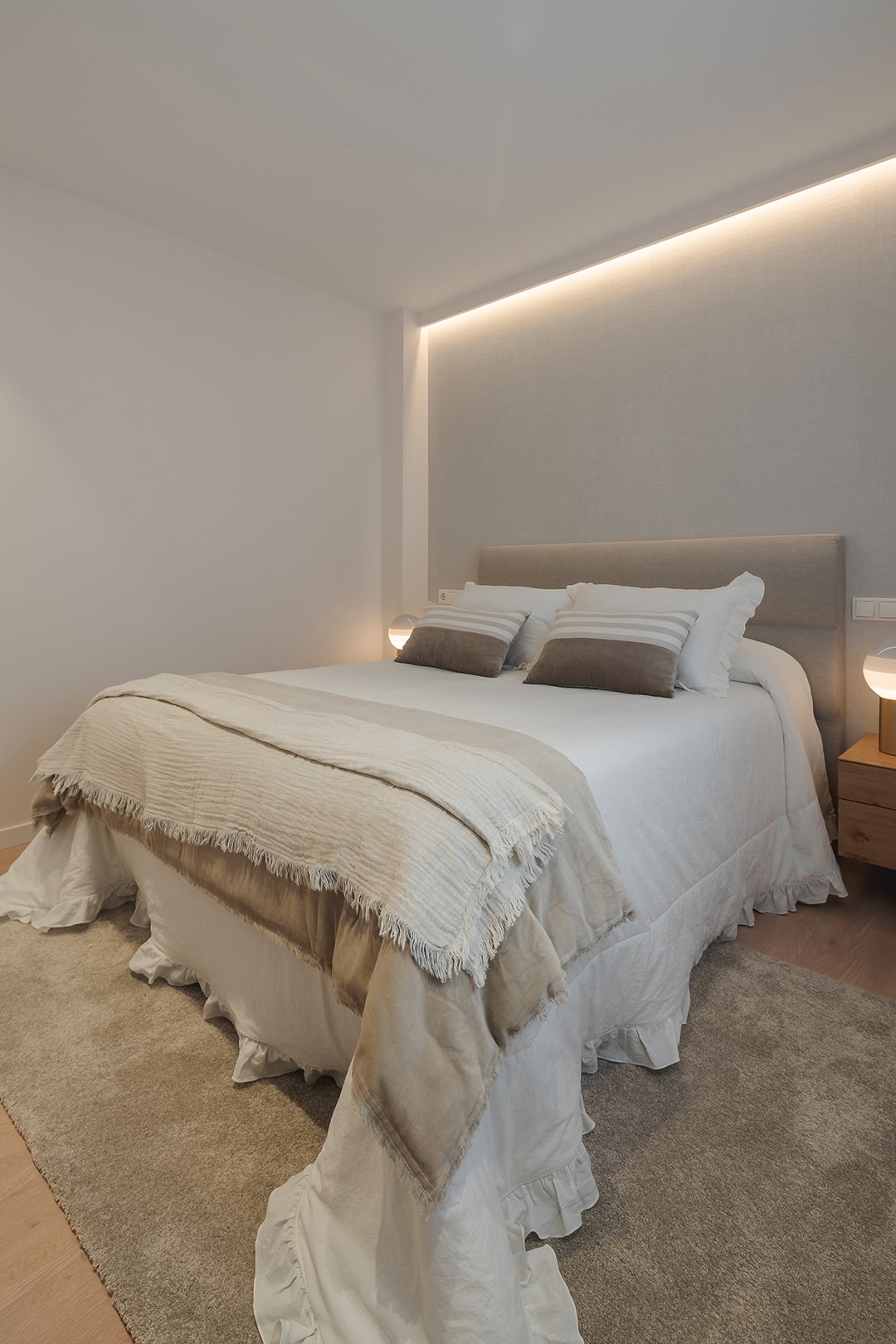 Bed in slaapkamer op verbouwde bovenverdieping met Santos keuken met glazen scheidingswand.