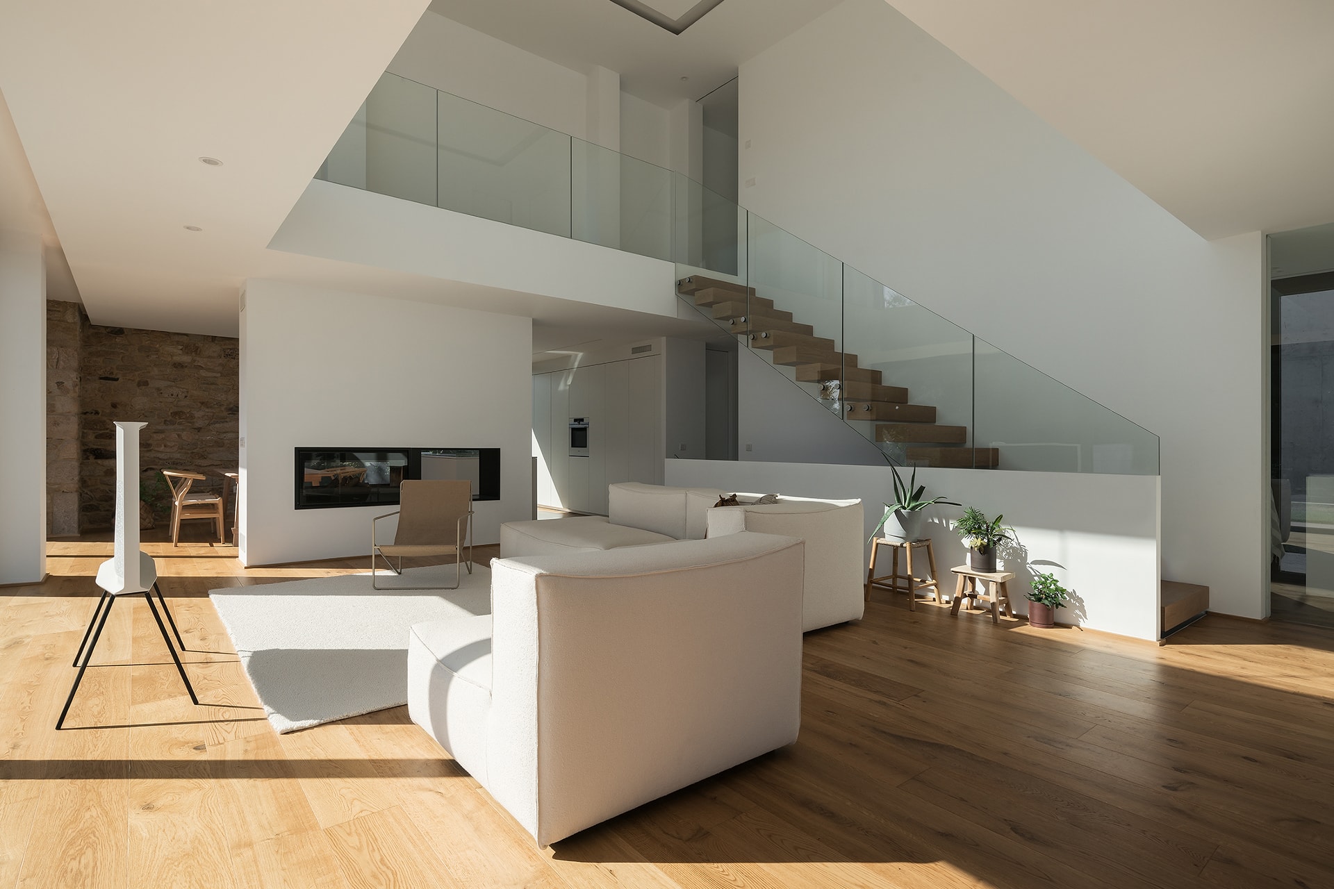 Salón en vivienda diseñada por Arnela Arquitectura con cocina abierta Santos.