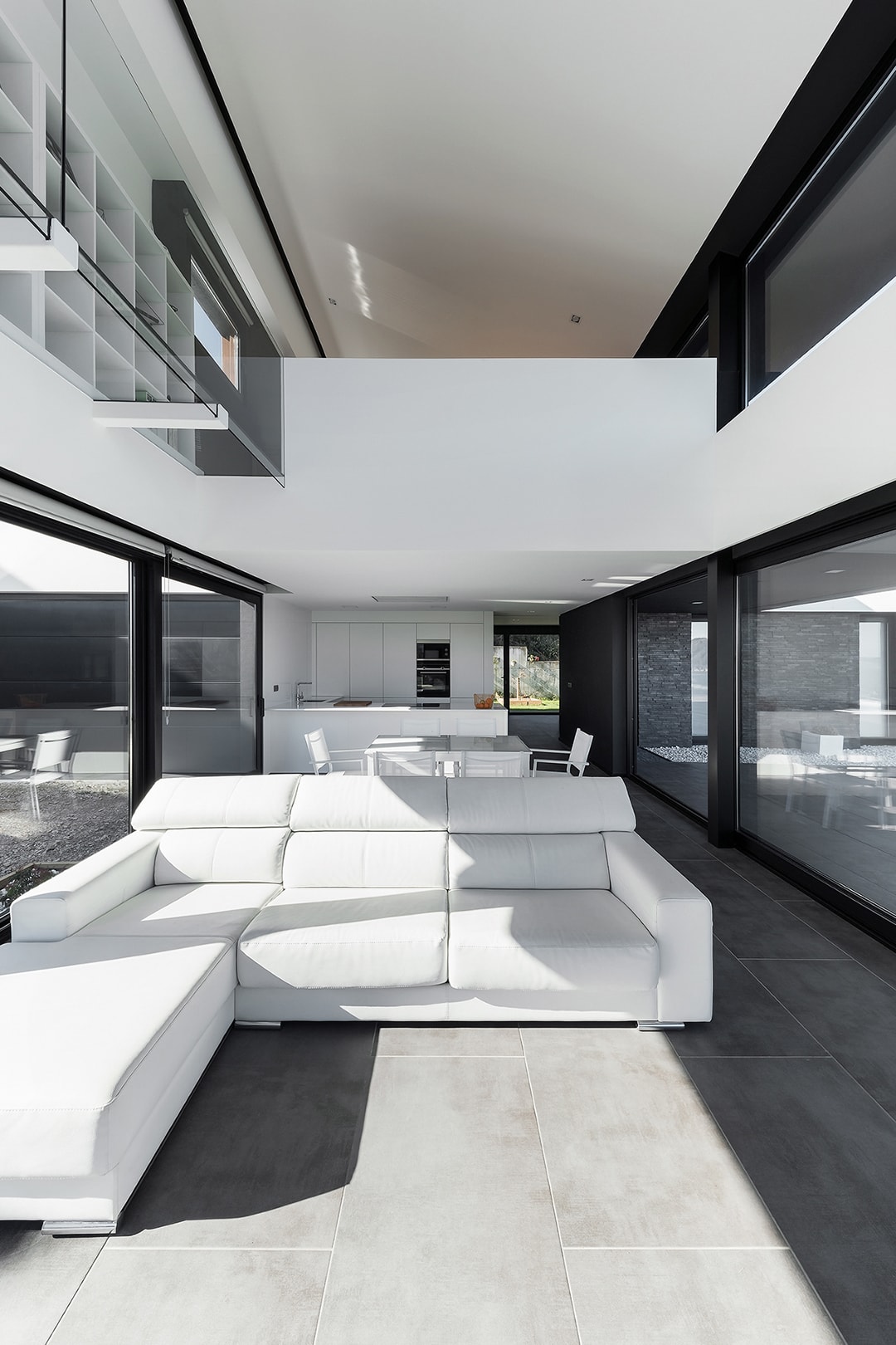 Cocina blanca abierta al salón comedor en vivienda diseñada por Arnela Arquitectura.