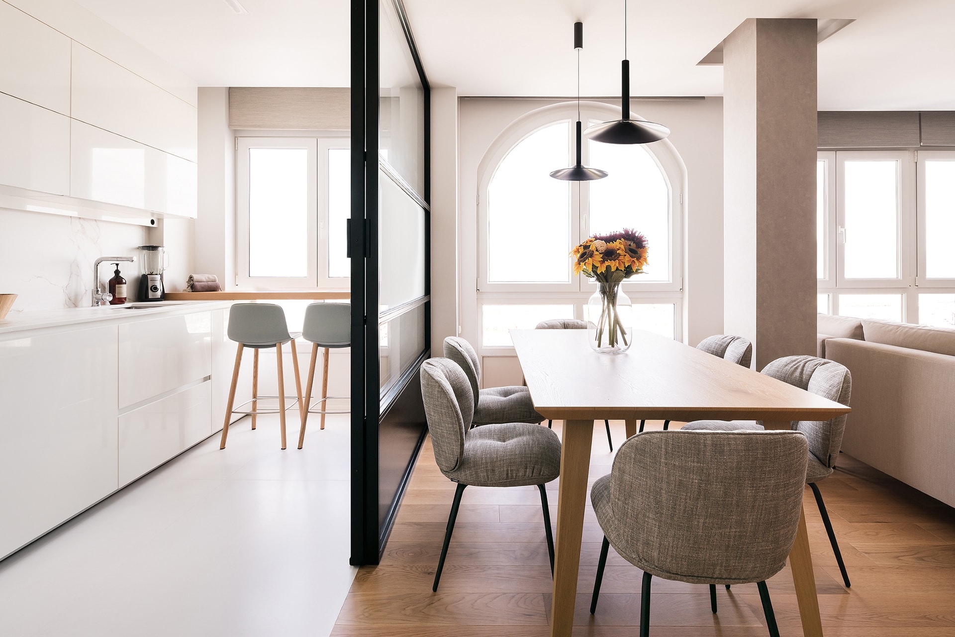 Cocina blanca con cerramiento de cristal en vivienda diseñada por Arnela Arquitectura.