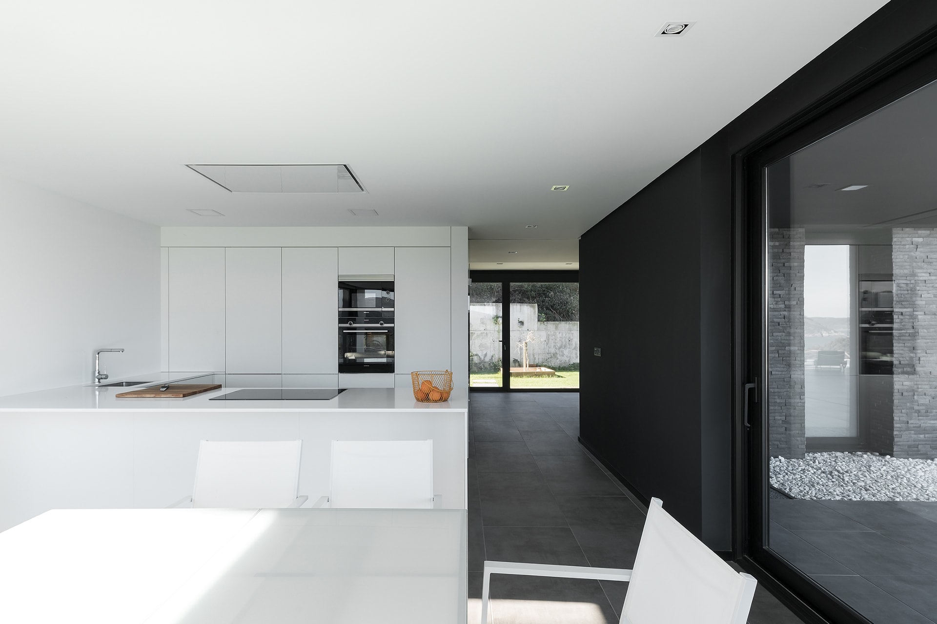 Cocina blanca Santos abierta al salón comedor, diseñada por Arnela Arquitectura.