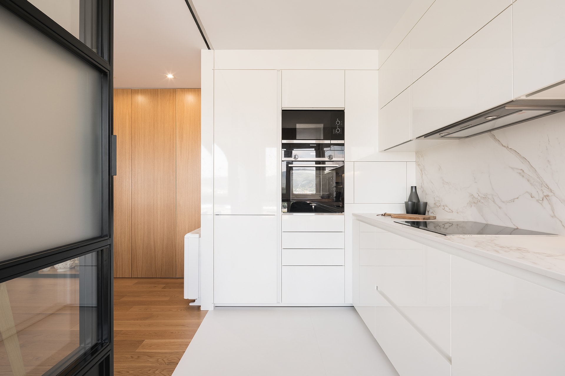 Cocina blanca Santos en L con electrodomésticos integrados.