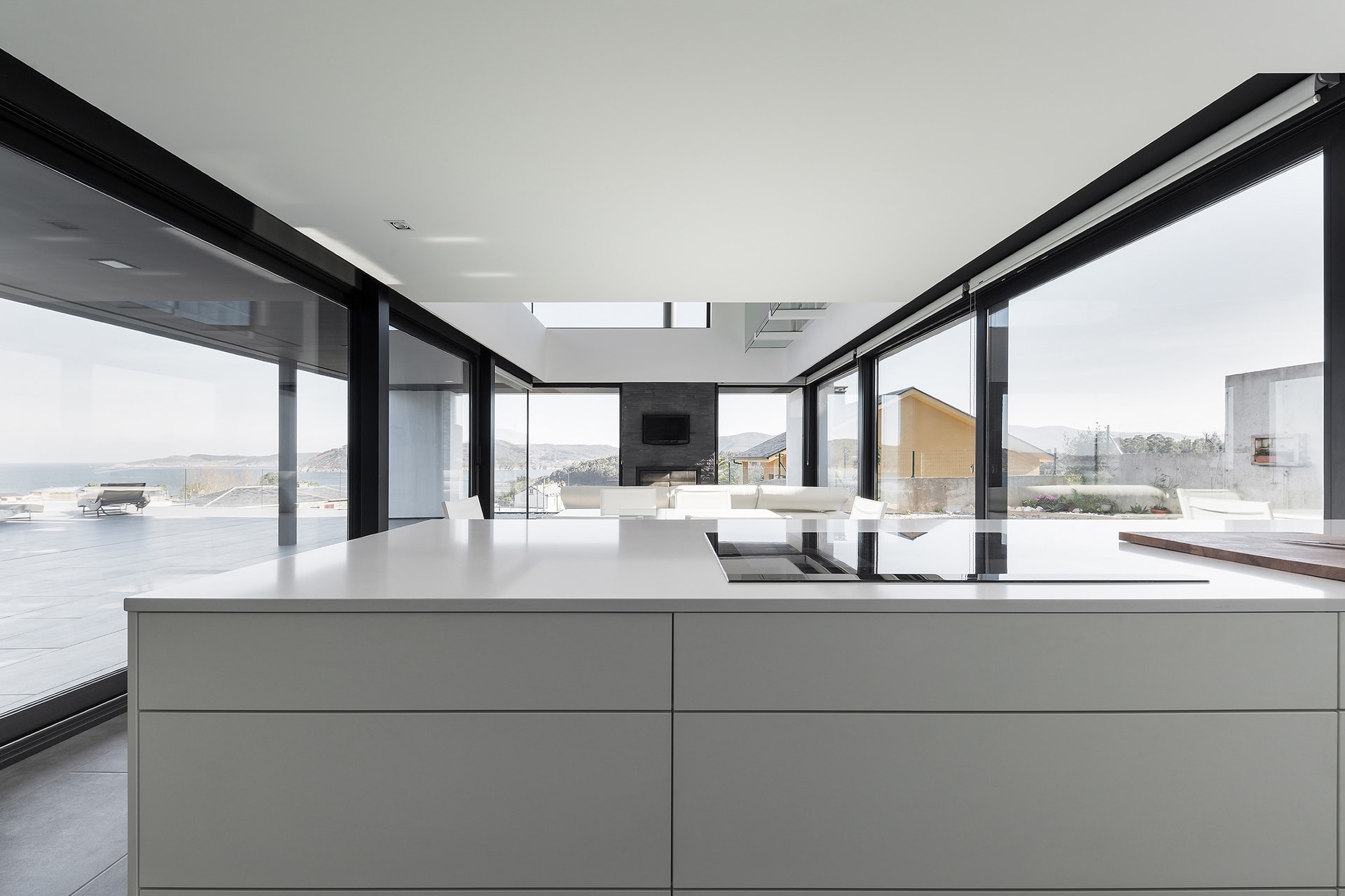 Cocina blanca Santos abierta al salón comedor en vivienda diseñada por Arnela Arquitectura.