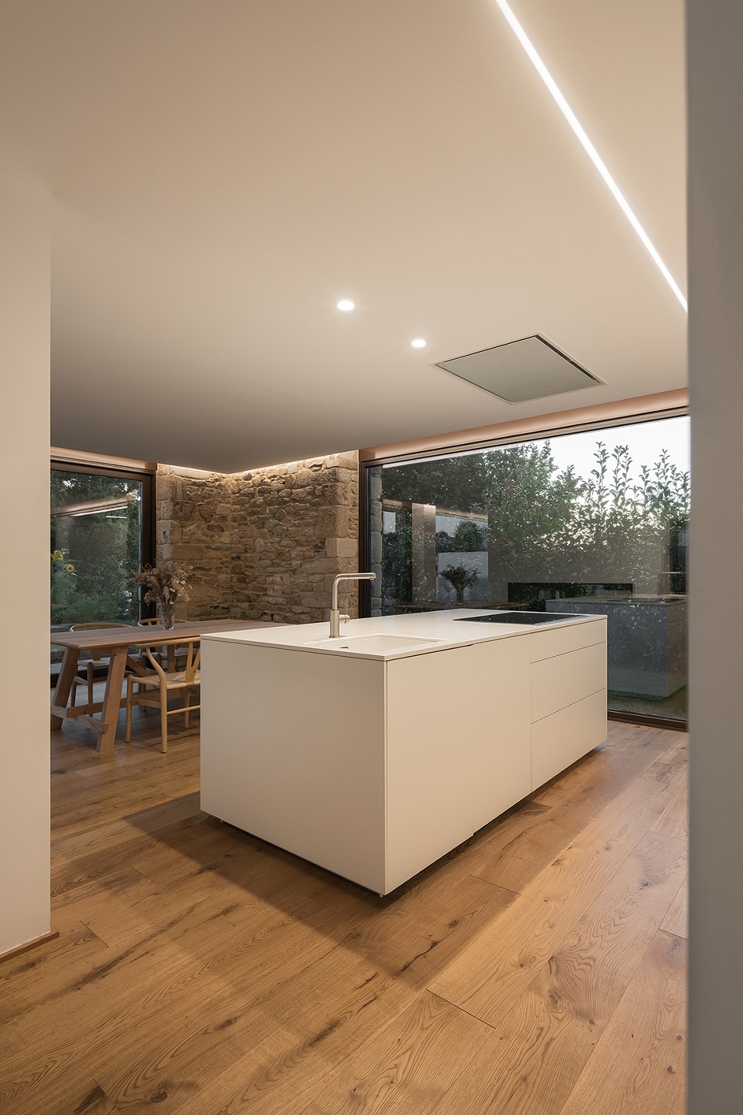 Cocina blanca Seff Santos abierta al comedor, en vivienda de Arnela Arquitectura.