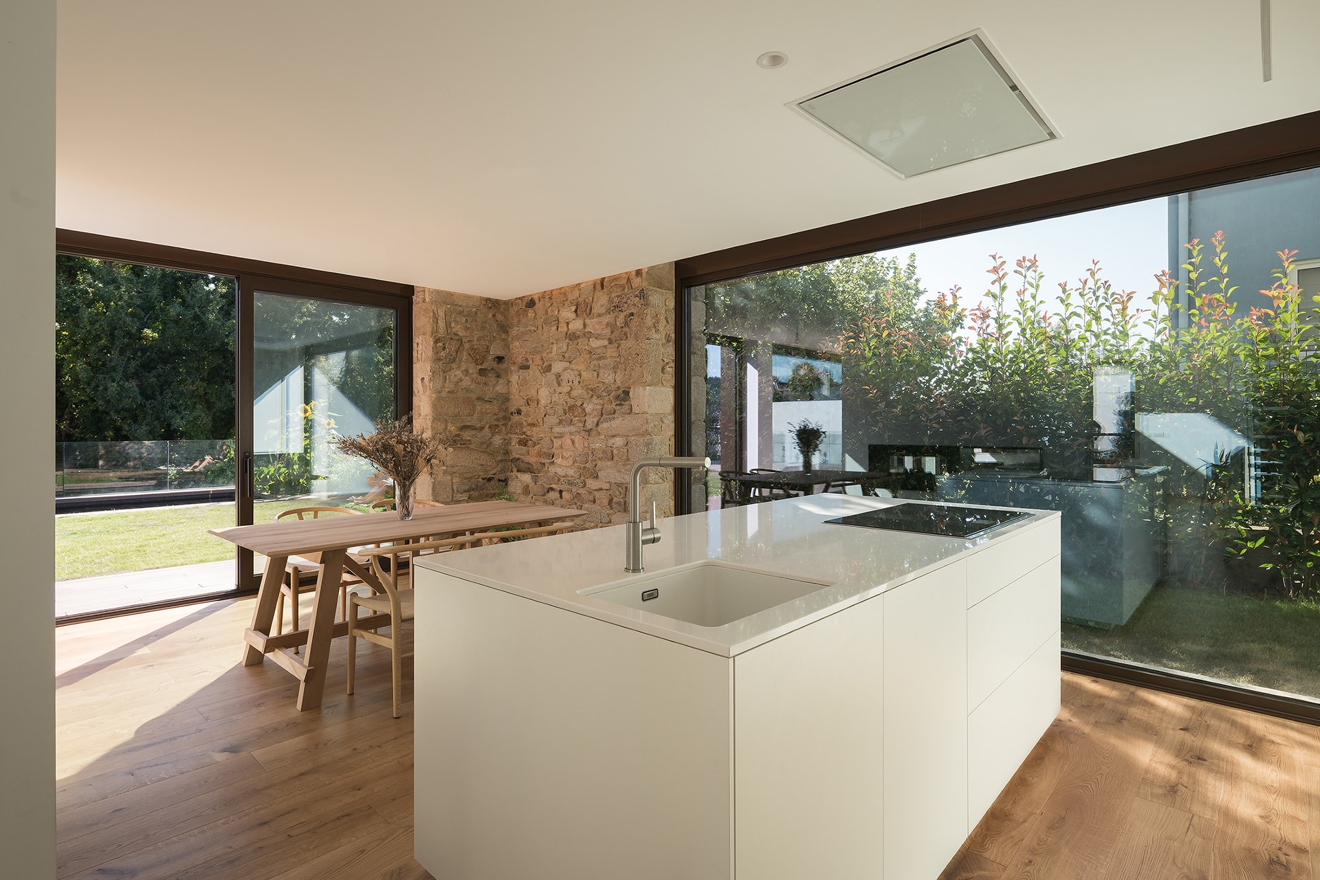 Cocina blanca Santos con isla en vivienda diseñada por Arnela Arquitectura.