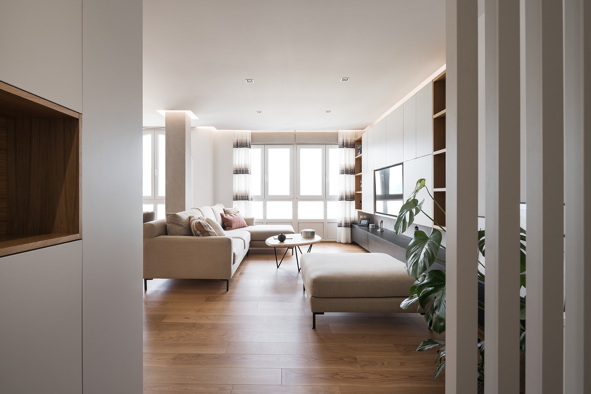 Vista de salón conectado con cocina abierta, en vivienda diseñada por Arnela Arquitectura.