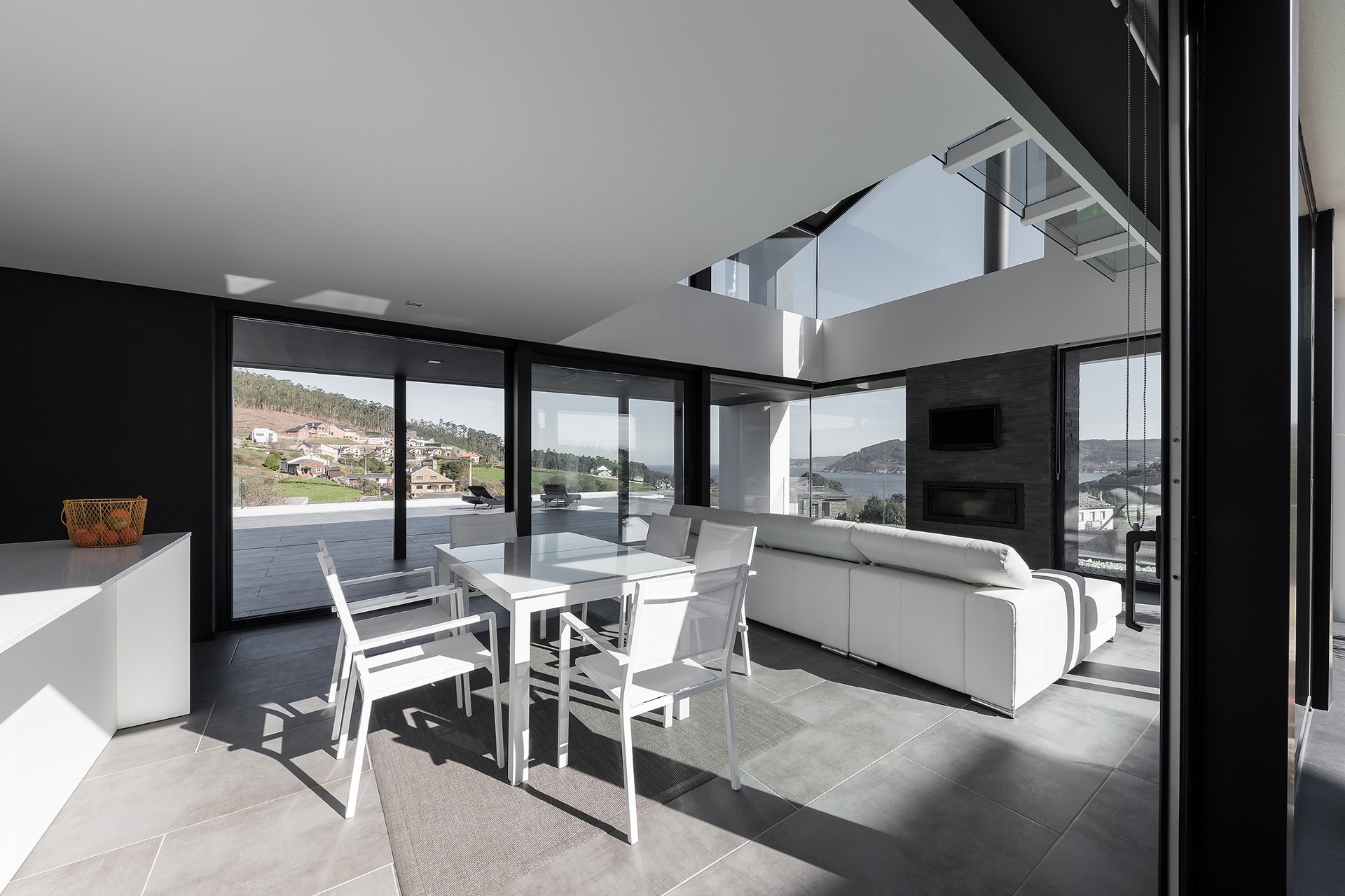 Salón comedor con cocina blanca Santos abierta, en vivienda diseñada por Arnela Arquitectura.