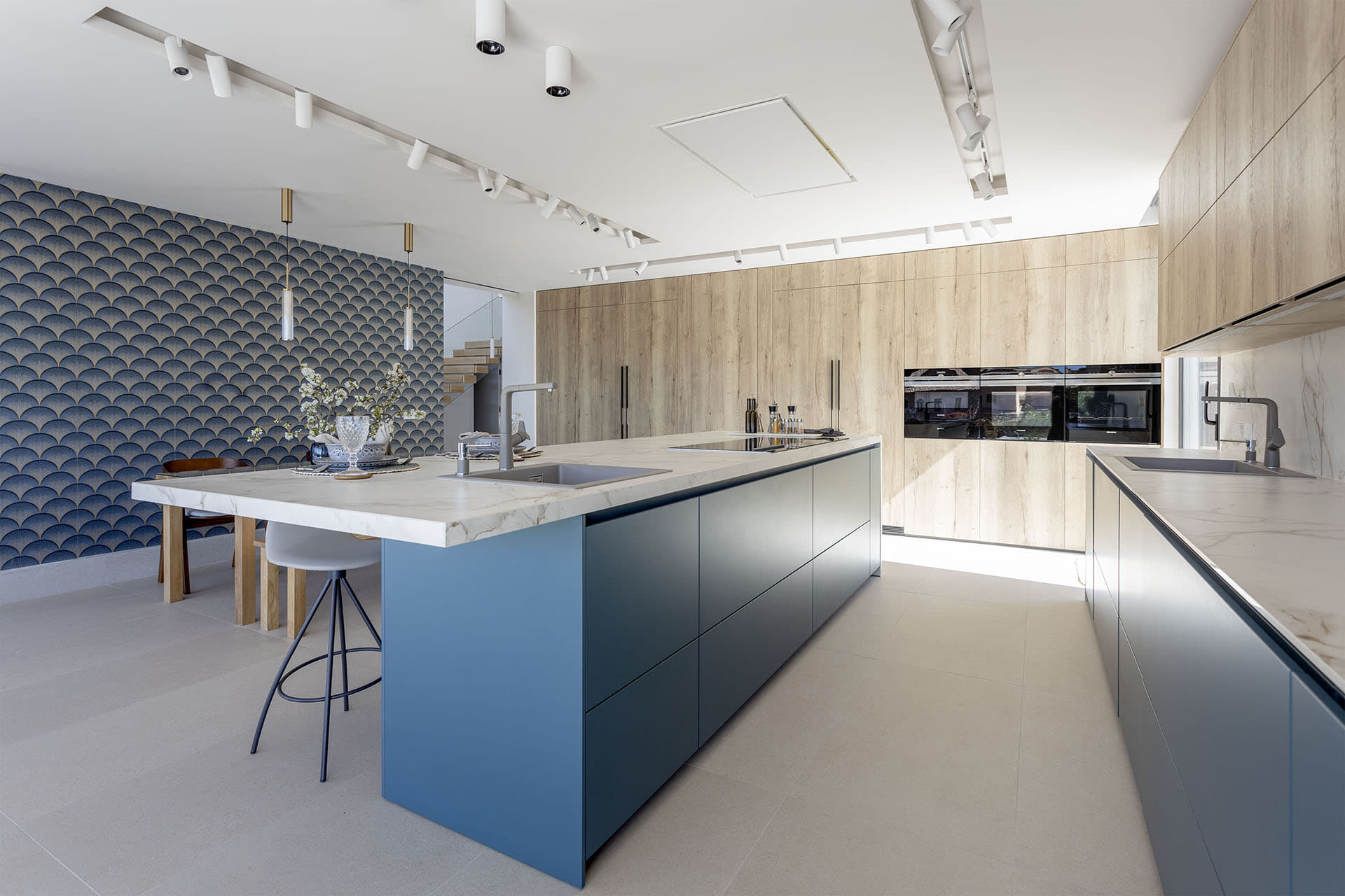 Cocina azul Santos con acabados en madera y electrodomésticos integrados.