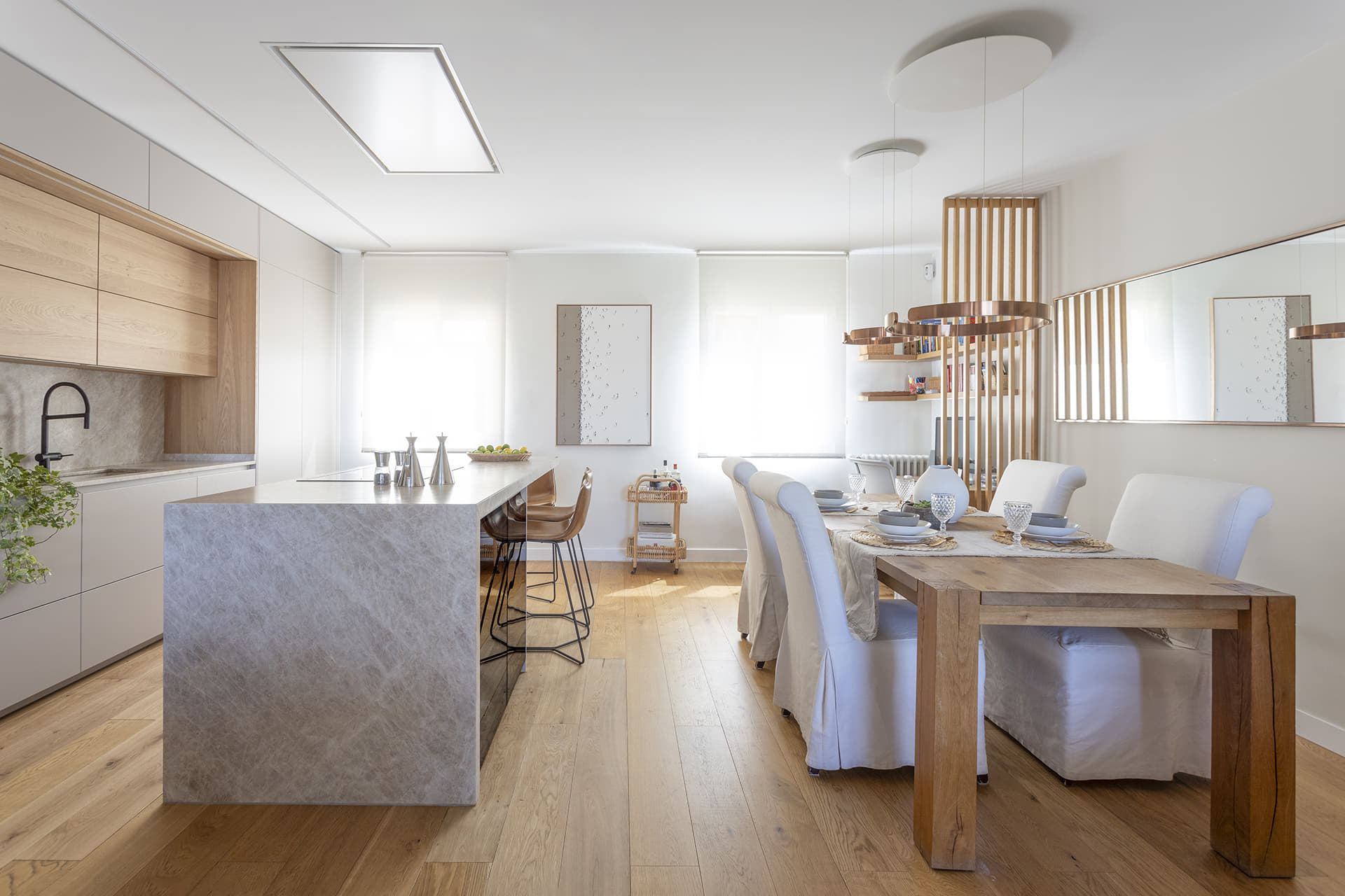 Cocina blanca abierta al comedor con isla diseñada por Santos.