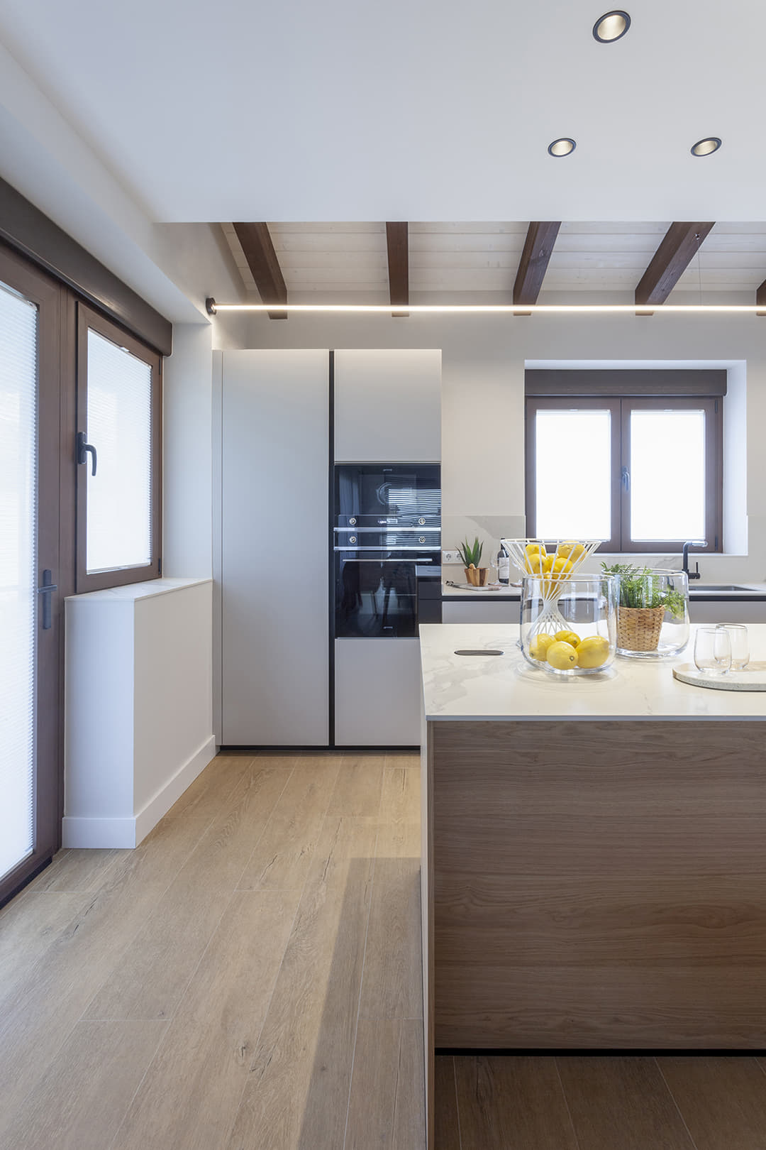 Cocina blanca y madera diseñada por Santos con isla.