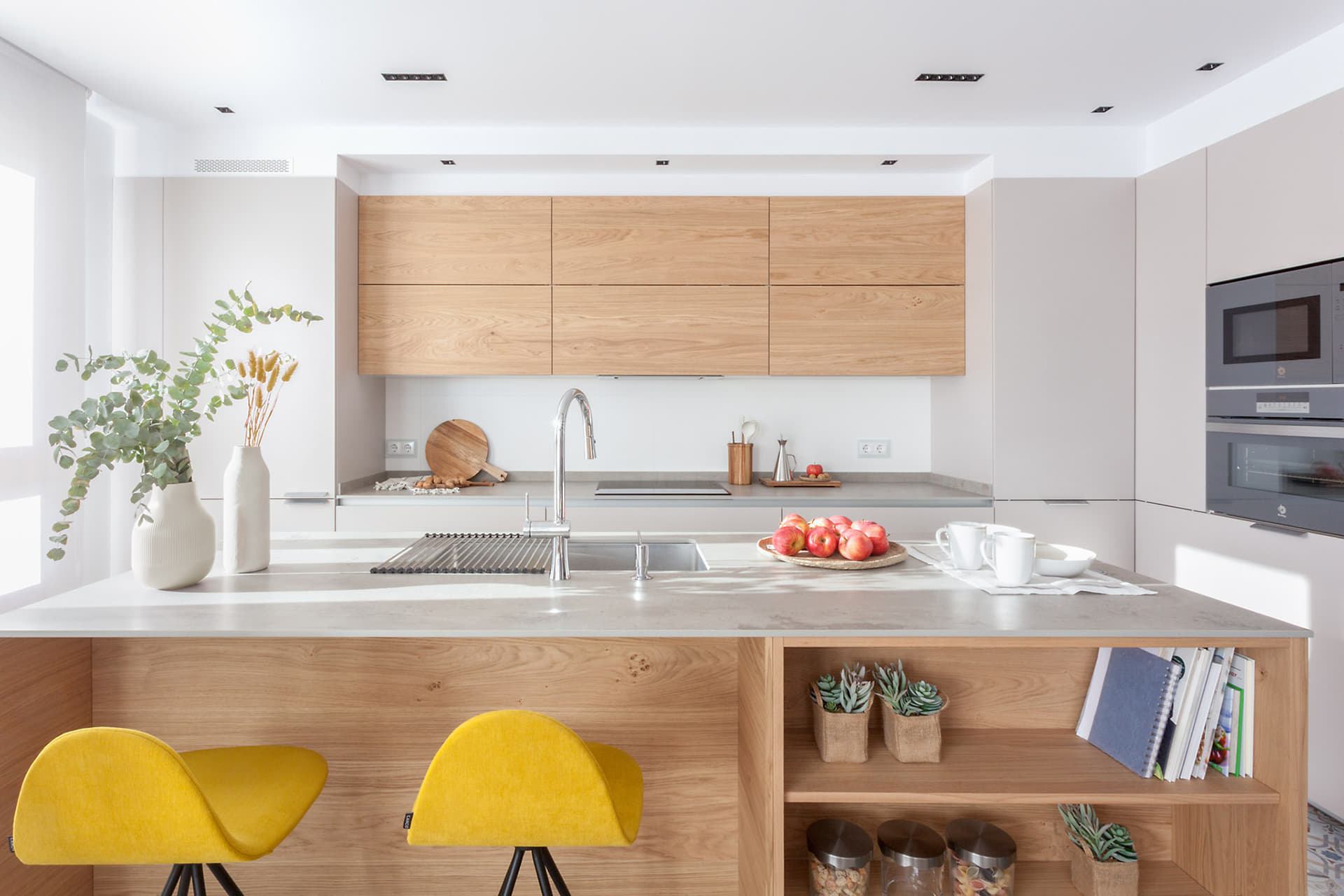 Cocina en L con isla abierta al salón comedor diseñada por Santos.