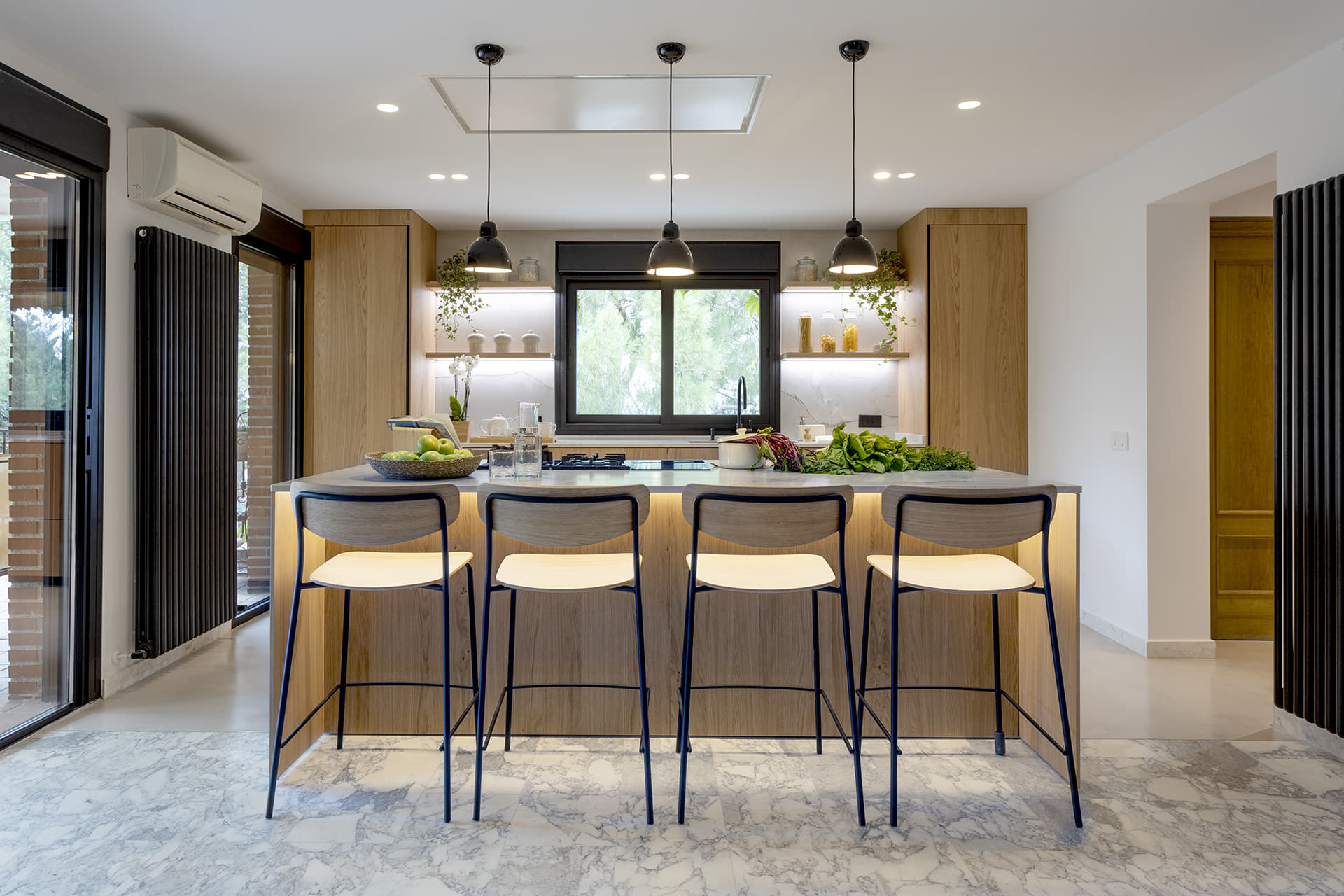 Cocina en madera con isla y barra para desayunos diseñada por Santos.