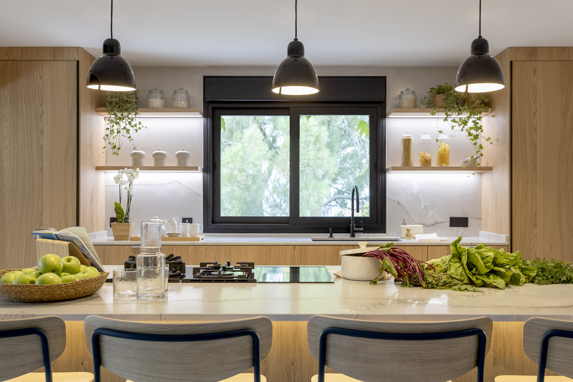 Cocina en madera Santos con isla y encimera blanca.